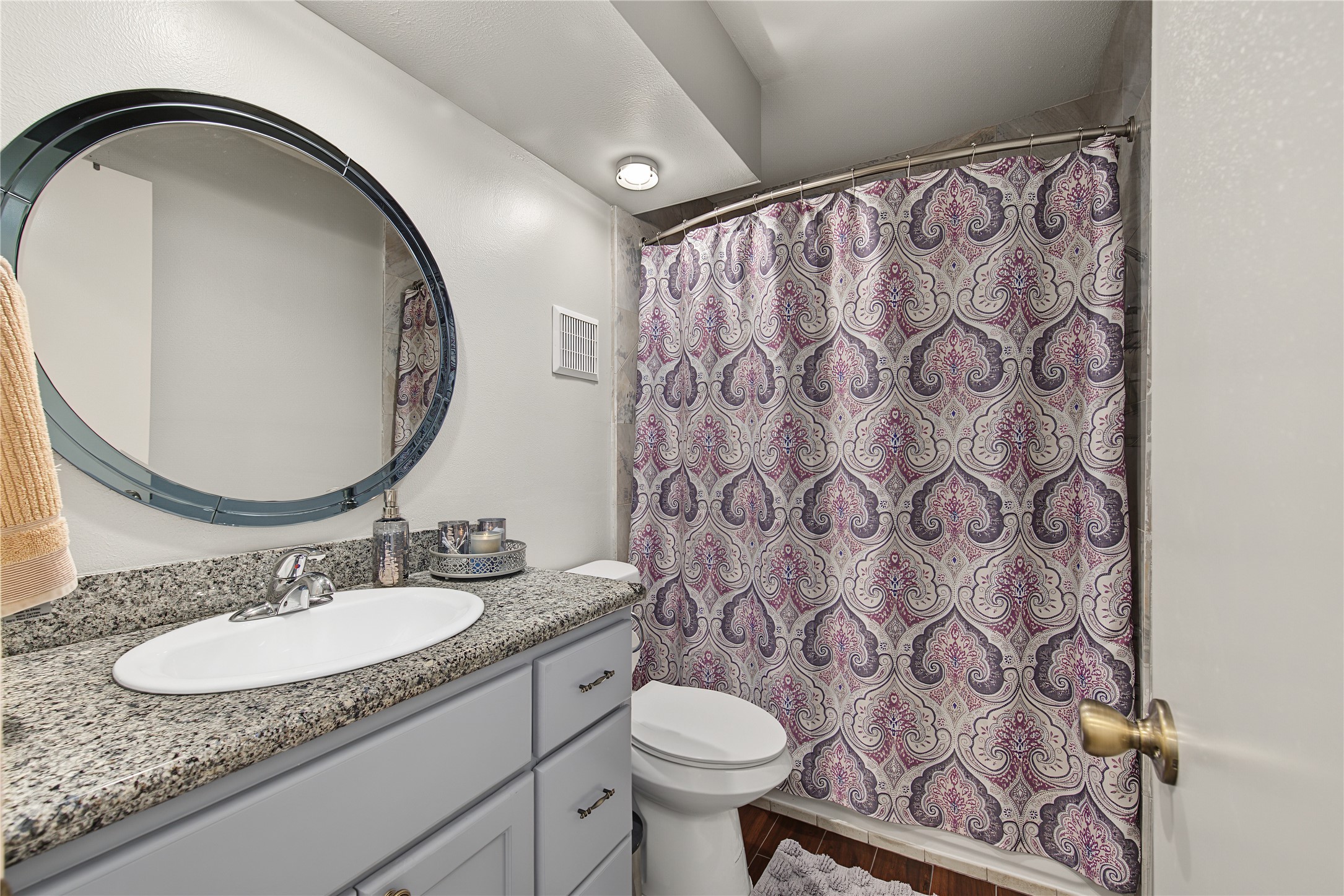 Secondary bathroom with granite countertop and tub-shower combination.
