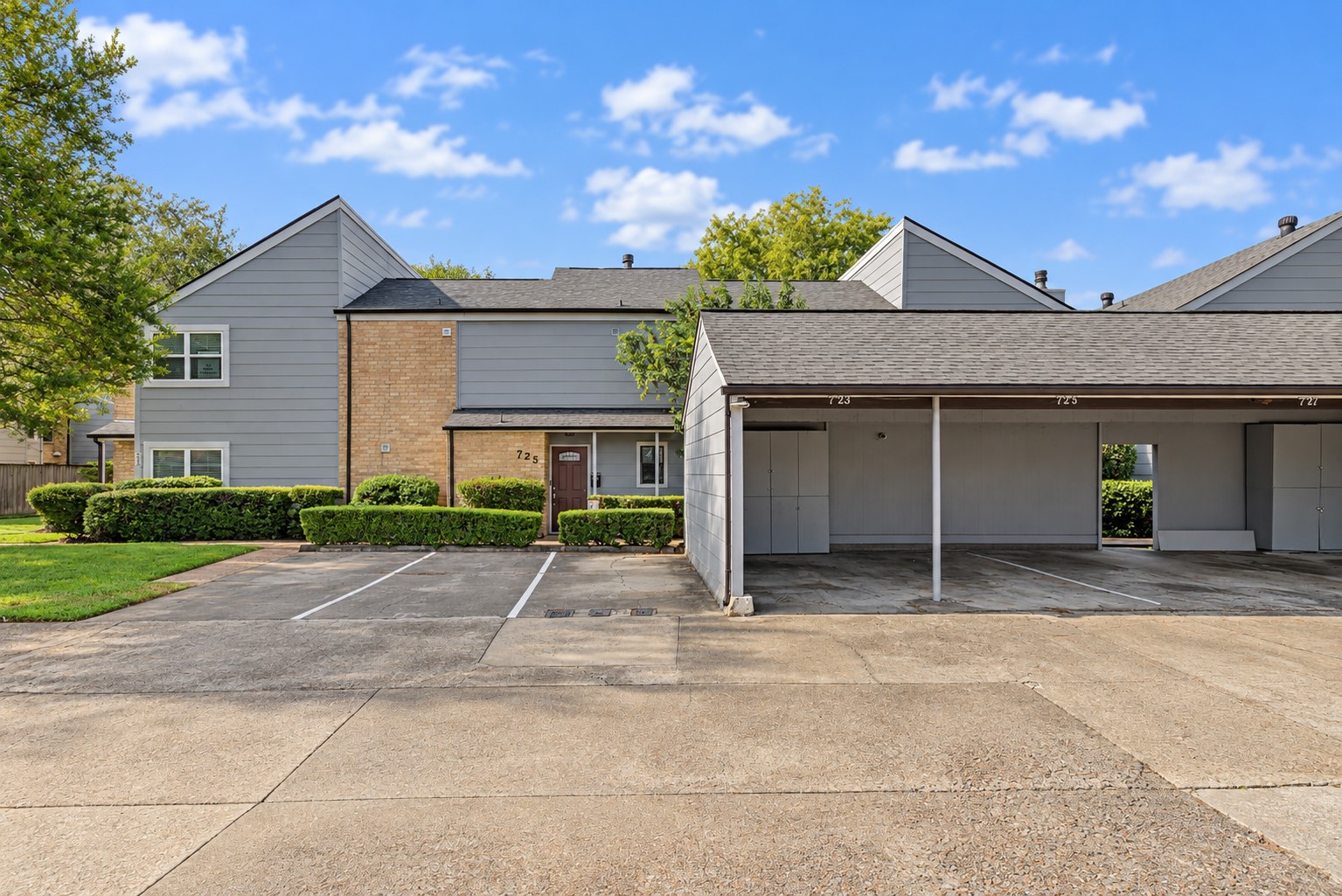 Front exterior showcasing townhome and covered parking area.