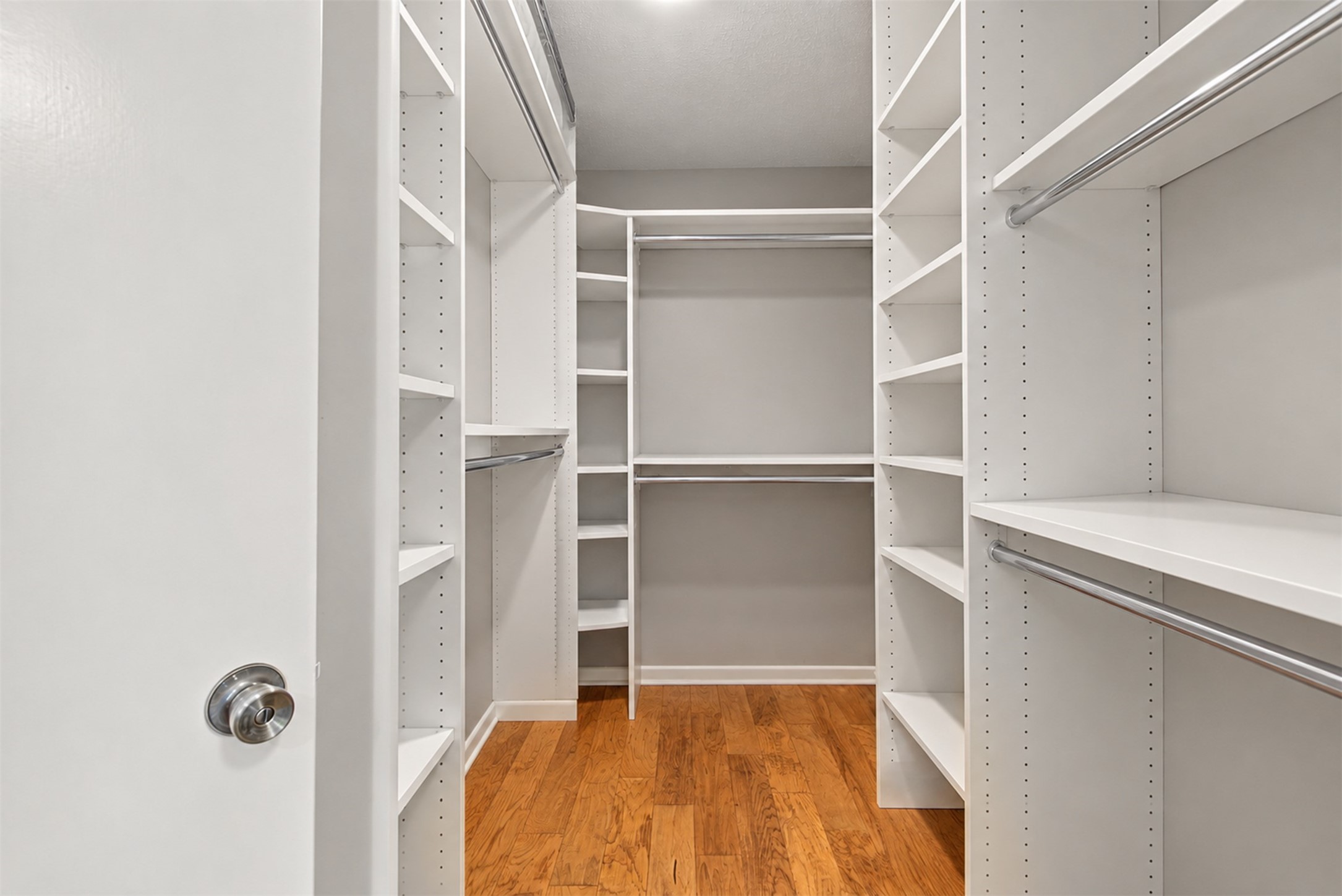 Large walk-in closet with extensive custom shelving and hanging space. Large walk-in closet with extensive custom shelving and hanging space.