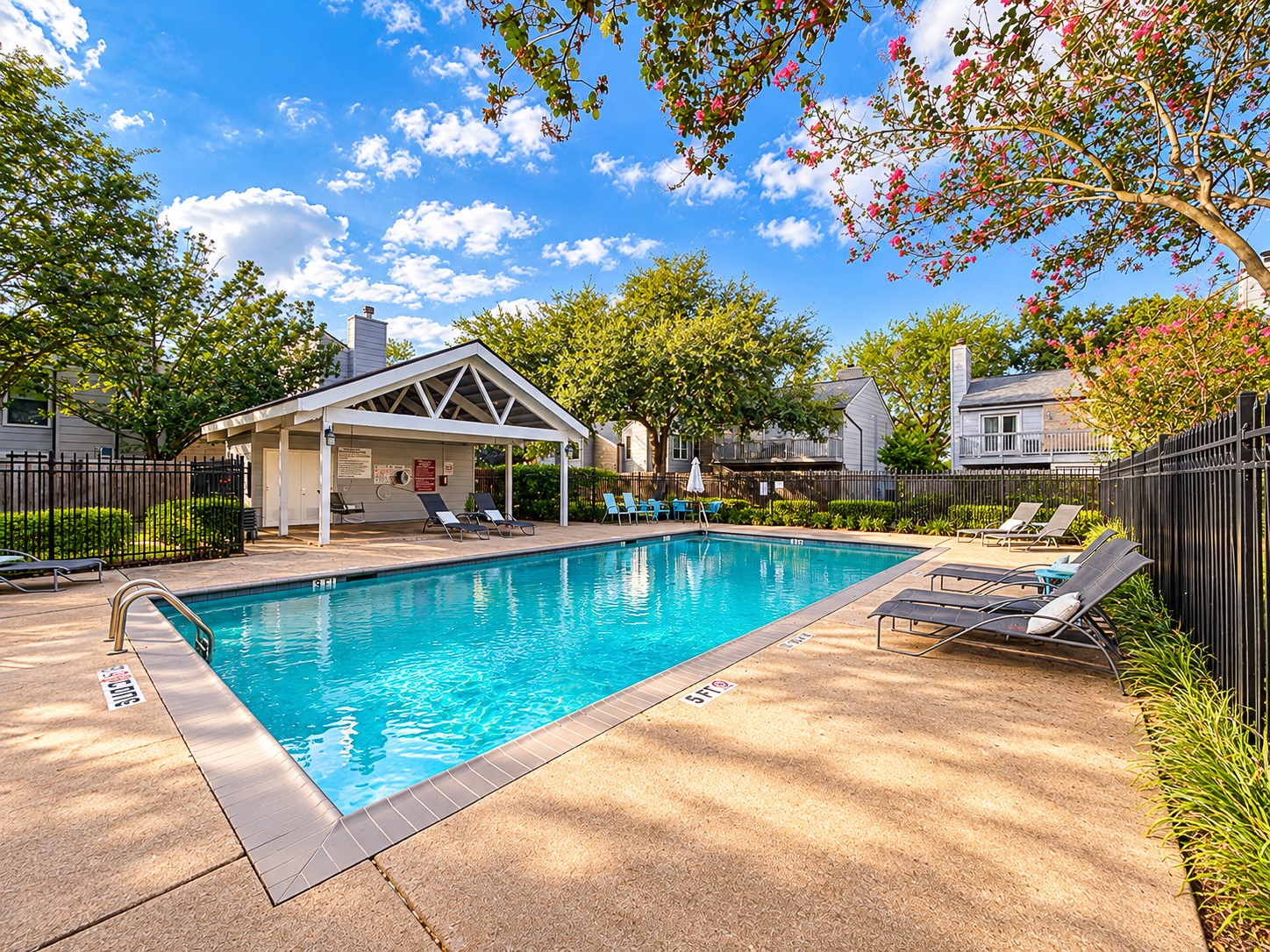 Community swimming pool with covered pavilion and lounge seating.