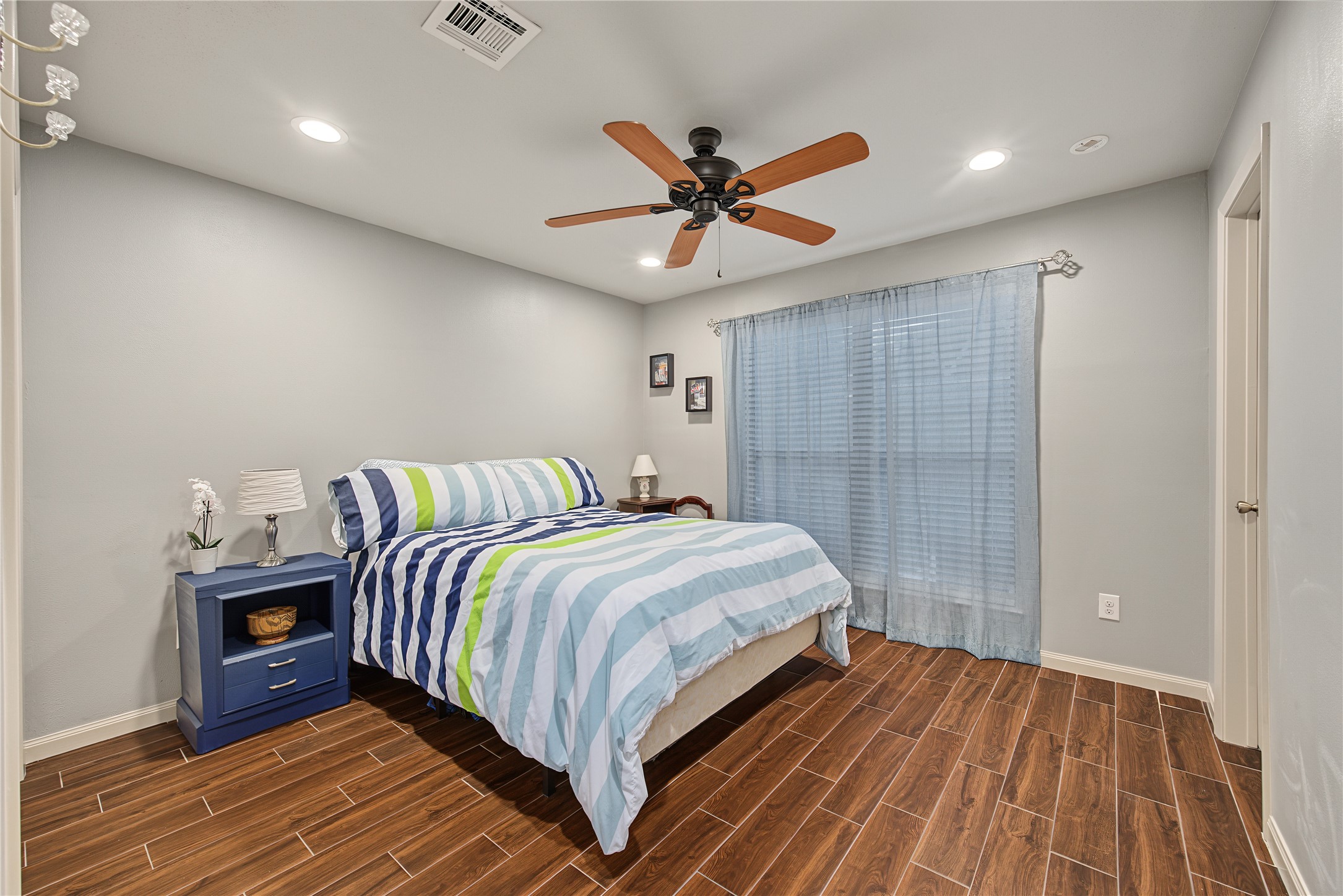Secondary bedroom with laminate flooring and ceiling fan.