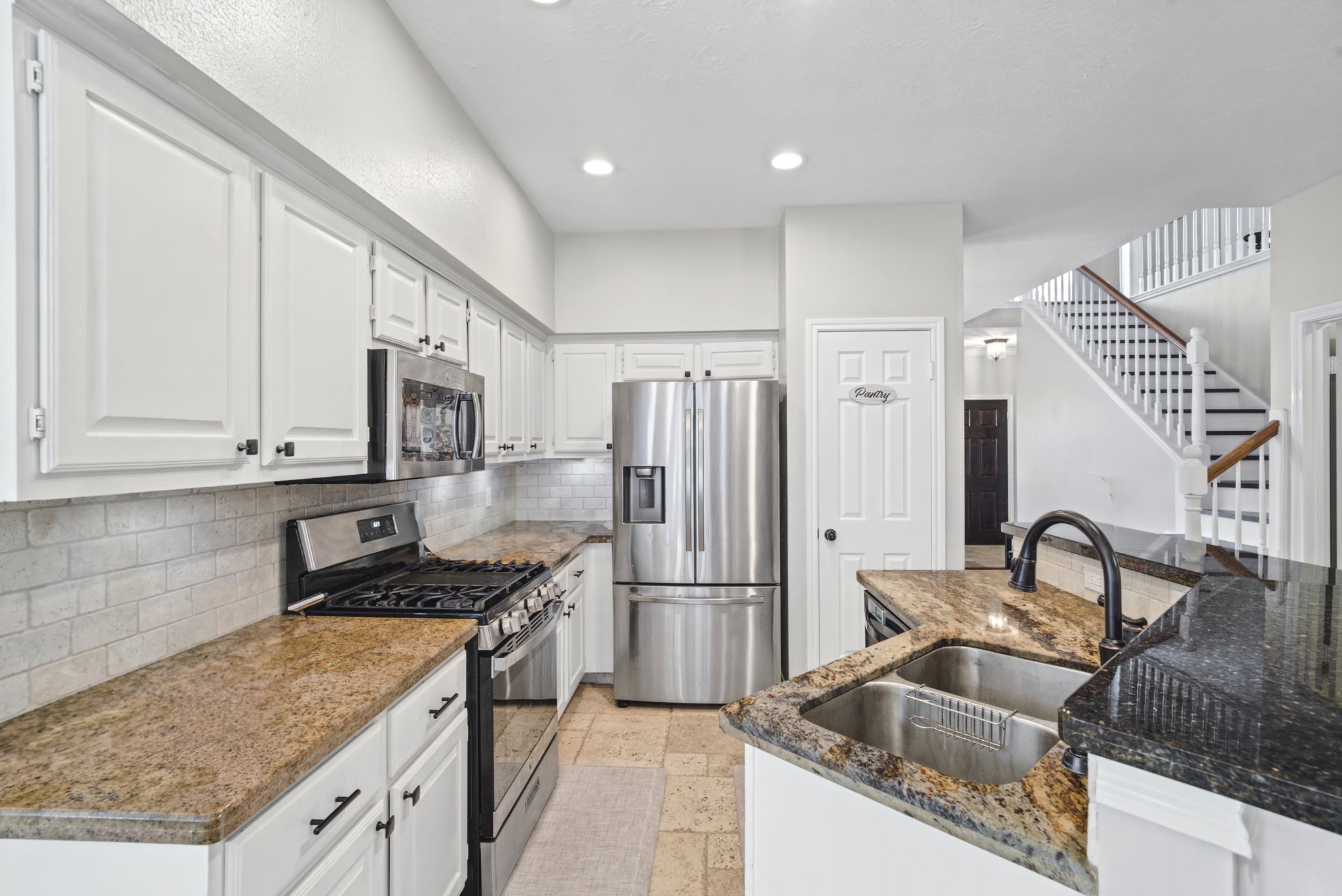 Enjoy a modern kitchen featuring elegant granite countertops, crisp white cabinetry, and sleek stainless steel appliances. A refrigerator is included for your convenience, completing this stylish and functional kitchen space.