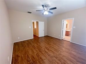 Primary bedroom is spacious with ceiling fand and beautiful floors