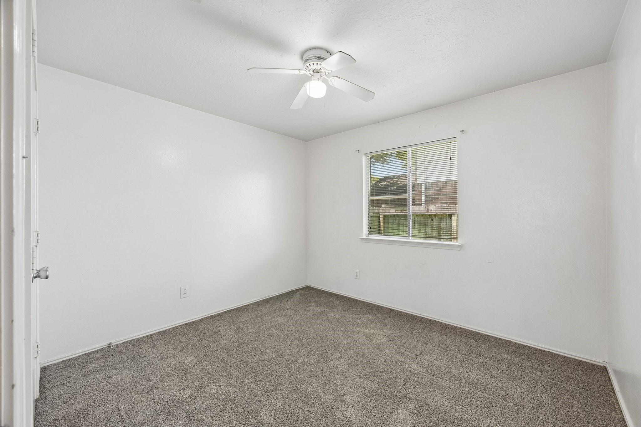 Secondary Bedroom Ceiling Fan, window treatment and clean carpet.
