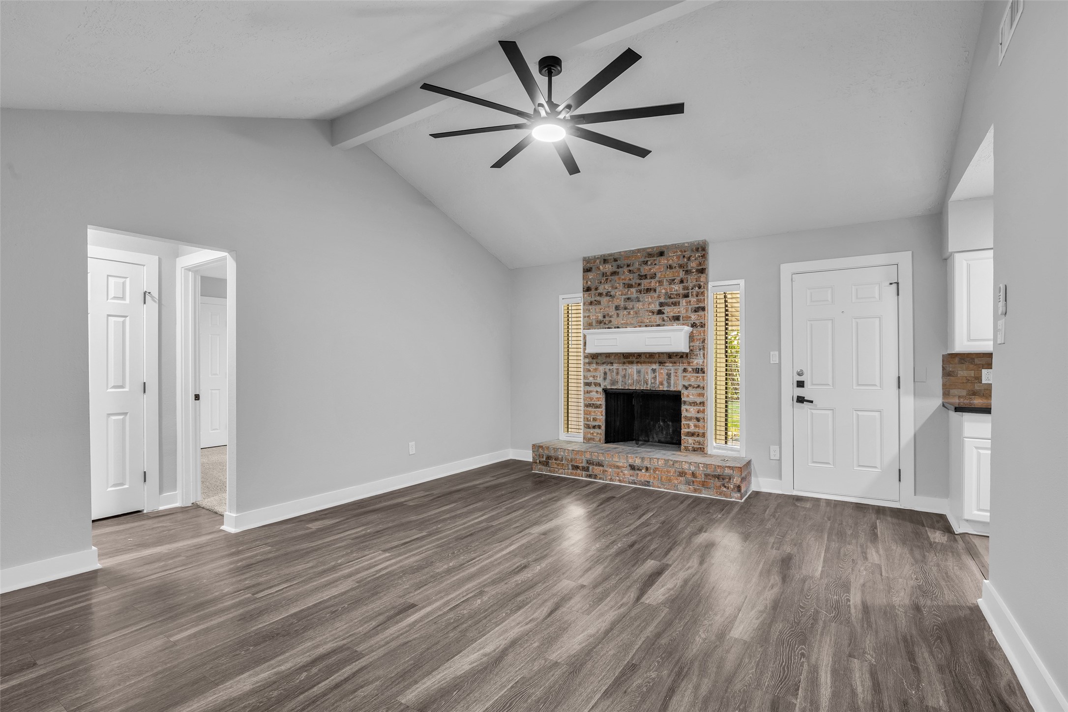 Vaulted ceiling with a beam detail adds volume, with easy access to the bedroom hallway.