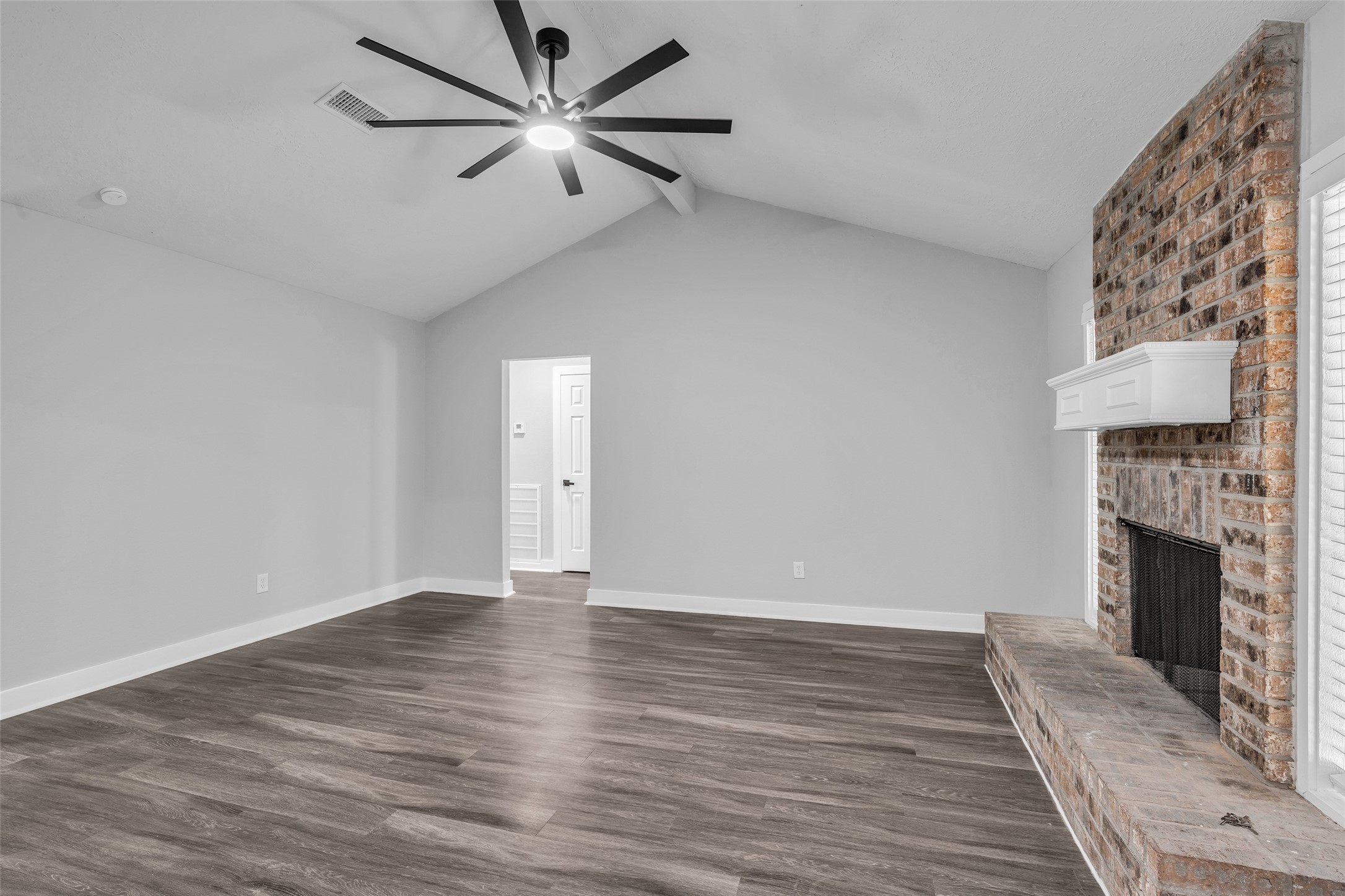 Plenty of room for a sectional and movie nights, with the brick fireplace as the focal point.