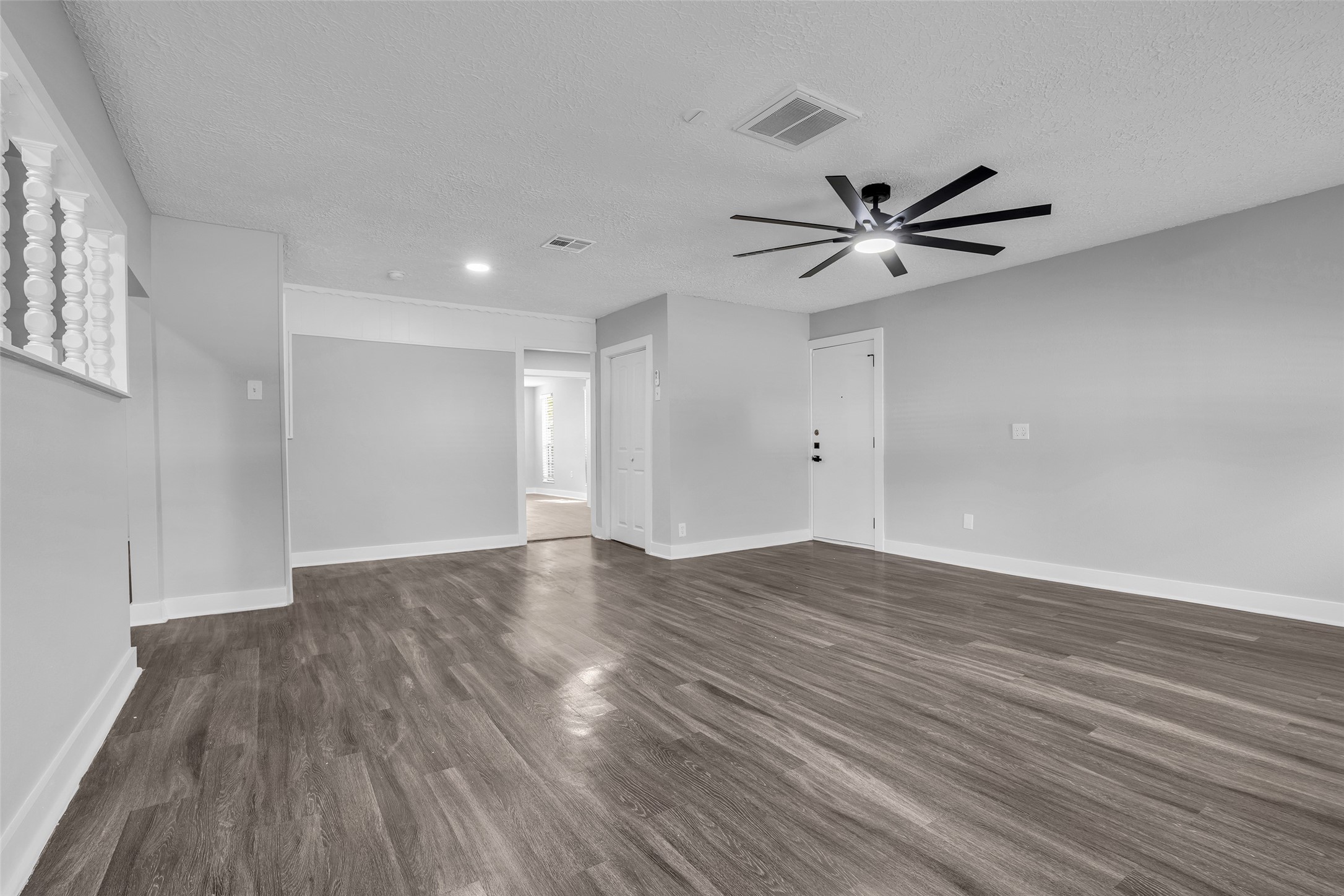 A second, oversized living space with a ceiling fan and recessed lighting, ready for game nights, a media setup or a home gym.
