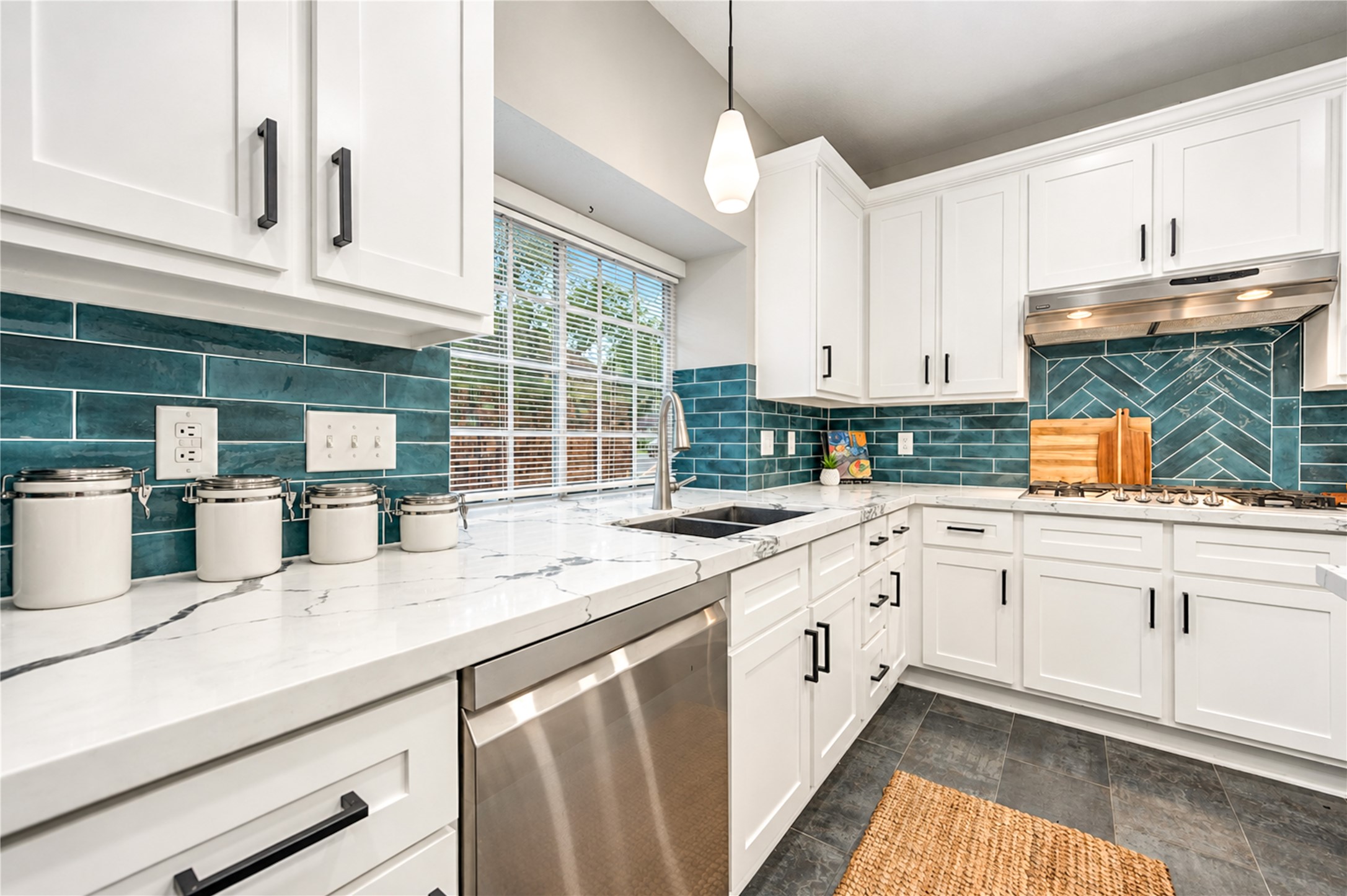 Cooking becomes a pleasure in this beautifully renovated kitchen! Generous quartz countertops offer plenty of room for meal prep, while stainless steel appliances, crisp white cabinetry and a striking subway tile backsplash bring style and function together. Whether creating a gourmet dinner or preparing a quick family favorite, everything you need is right at your fingertips!