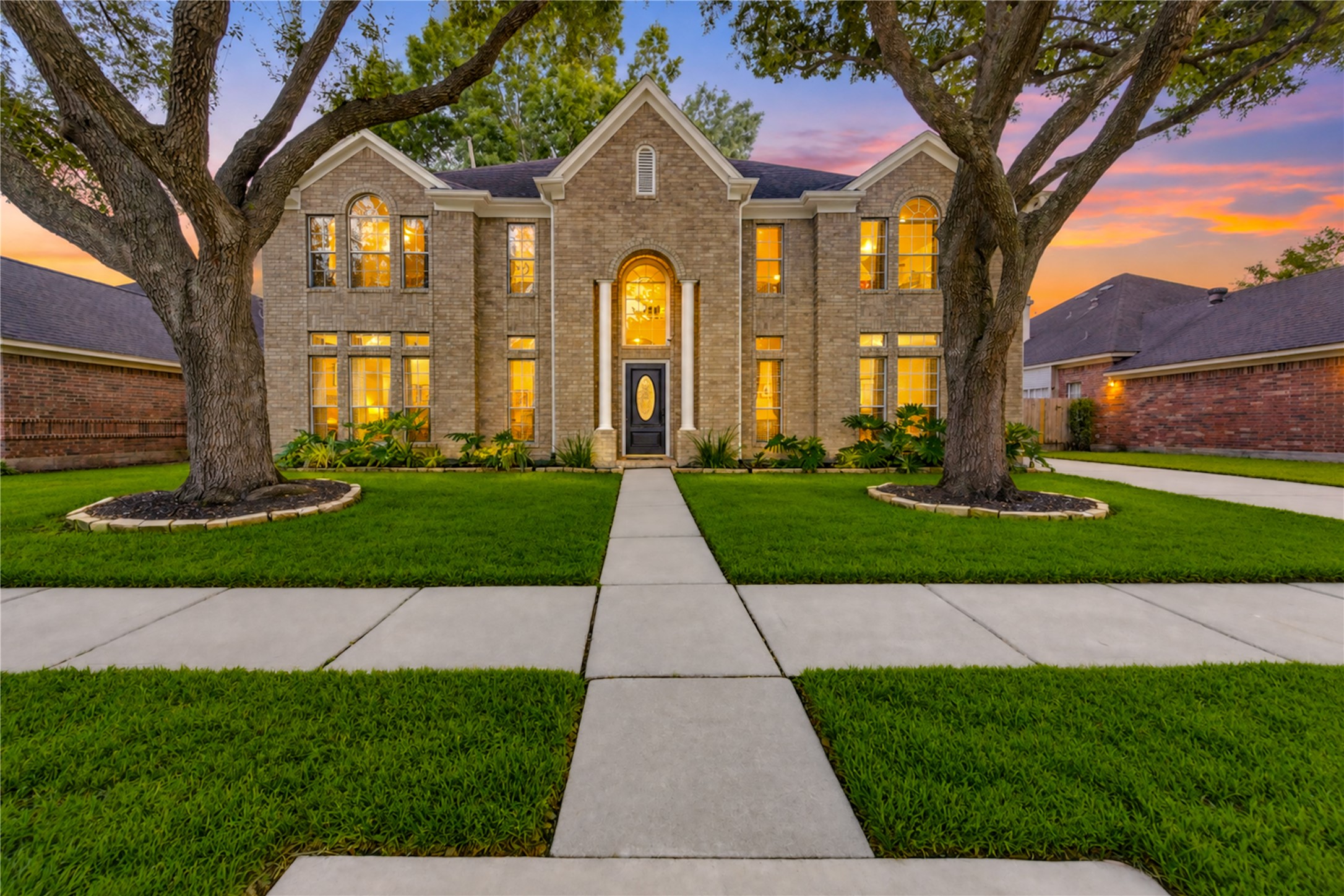 A warm welcome home! Beautifully illuminated at dusk, this charming two-story home showcases inviting curb appeal, mature shade trees, lush landscaping and a picturesque walkway leading to the front entrance. A warm welcome home! Beautifully illuminated at dusk, this charming two-story home showcases inviting curb appeal, mature shade trees, lush landscaping and a picturesque walkway leading to the front entrance.