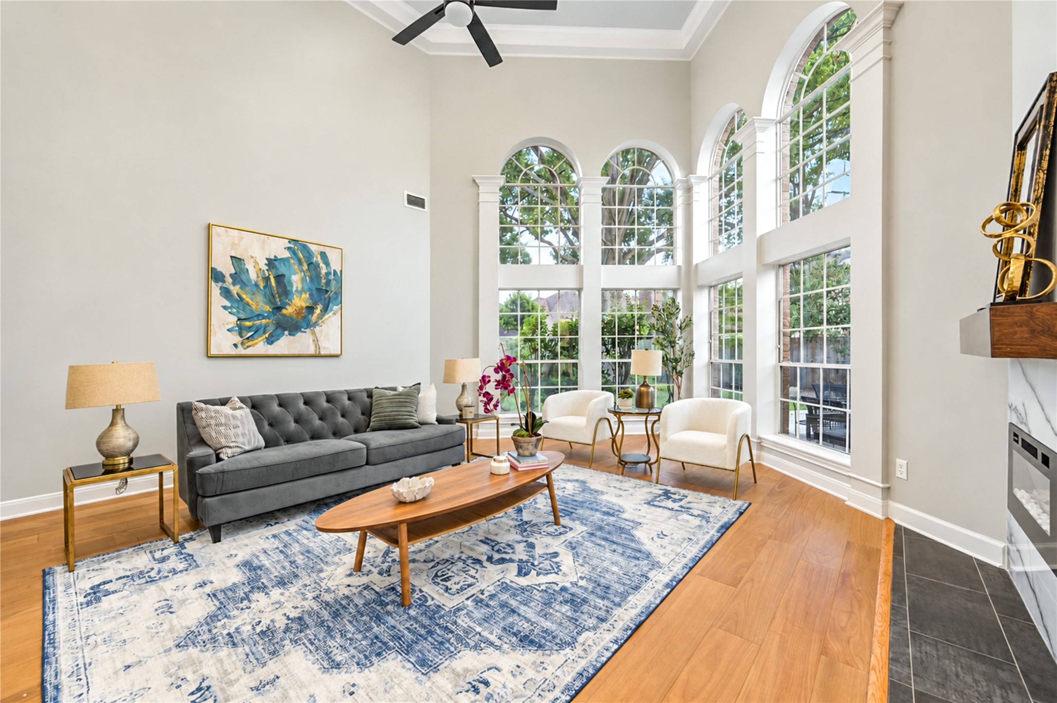 Bathed in natural light from dramatic two-story windows, this beautiful family room invites you to slow down and enjoy life's everyday moments. From cozy evenings by the fireplace to lively gatherings with friends, soaring ceilings and picturesque backyard views create a warm, welcoming space you'll love coming home to!