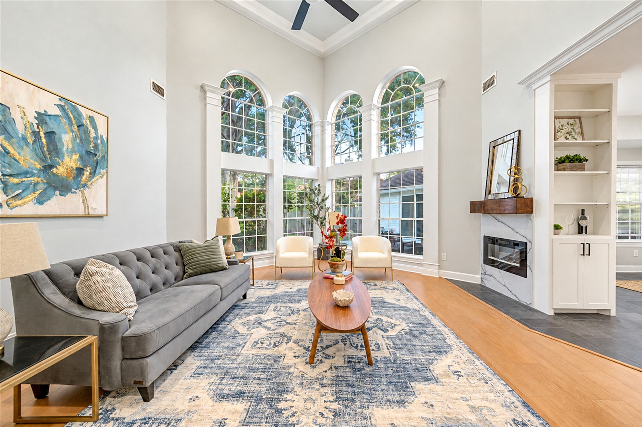 The perfect place to relax, reconnect and make lasting memories! This stunning family room features soaring ceilings, beautiful arched windows that fill the space with natural light and a cozy fireplace. Whether enjoying movie nights, gathering with friends or simply unwinding after a busy day, this inviting space makes everyday living feel extraordinary!