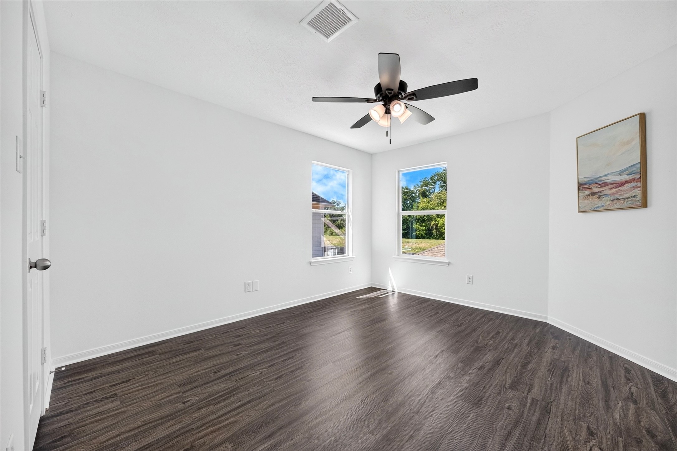 Bedroom with two windows for natural light and a NEW ceiling fan.