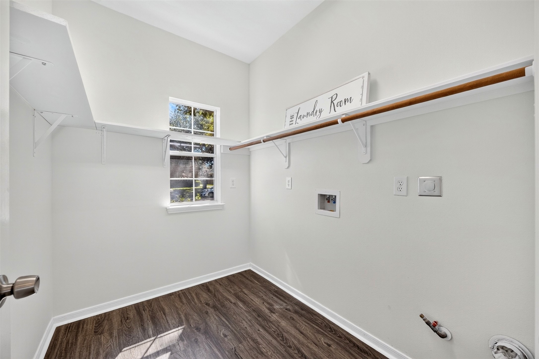 Laundry room with ample shelving and a convenient window for natural light.