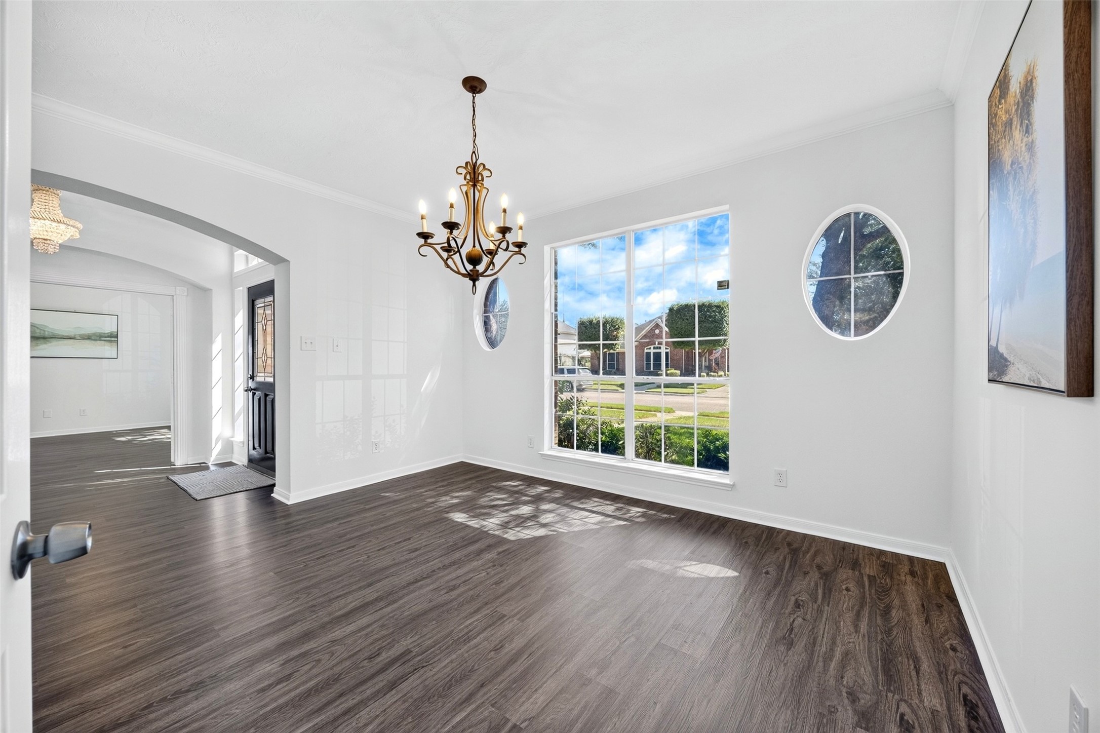 Bright and airy dining room with large windows and an elegant chandelier, perfect for gatherings