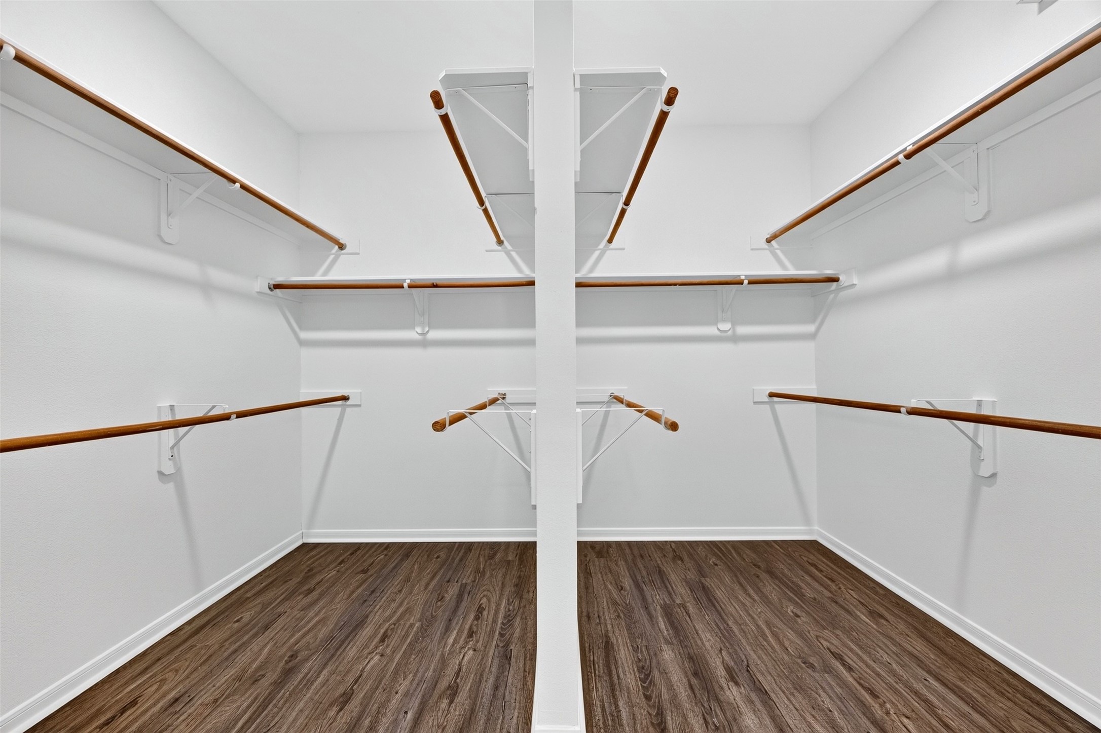 Spacious walk-in closet with multiple hanging rods, perfect for organizing your wardrobe.