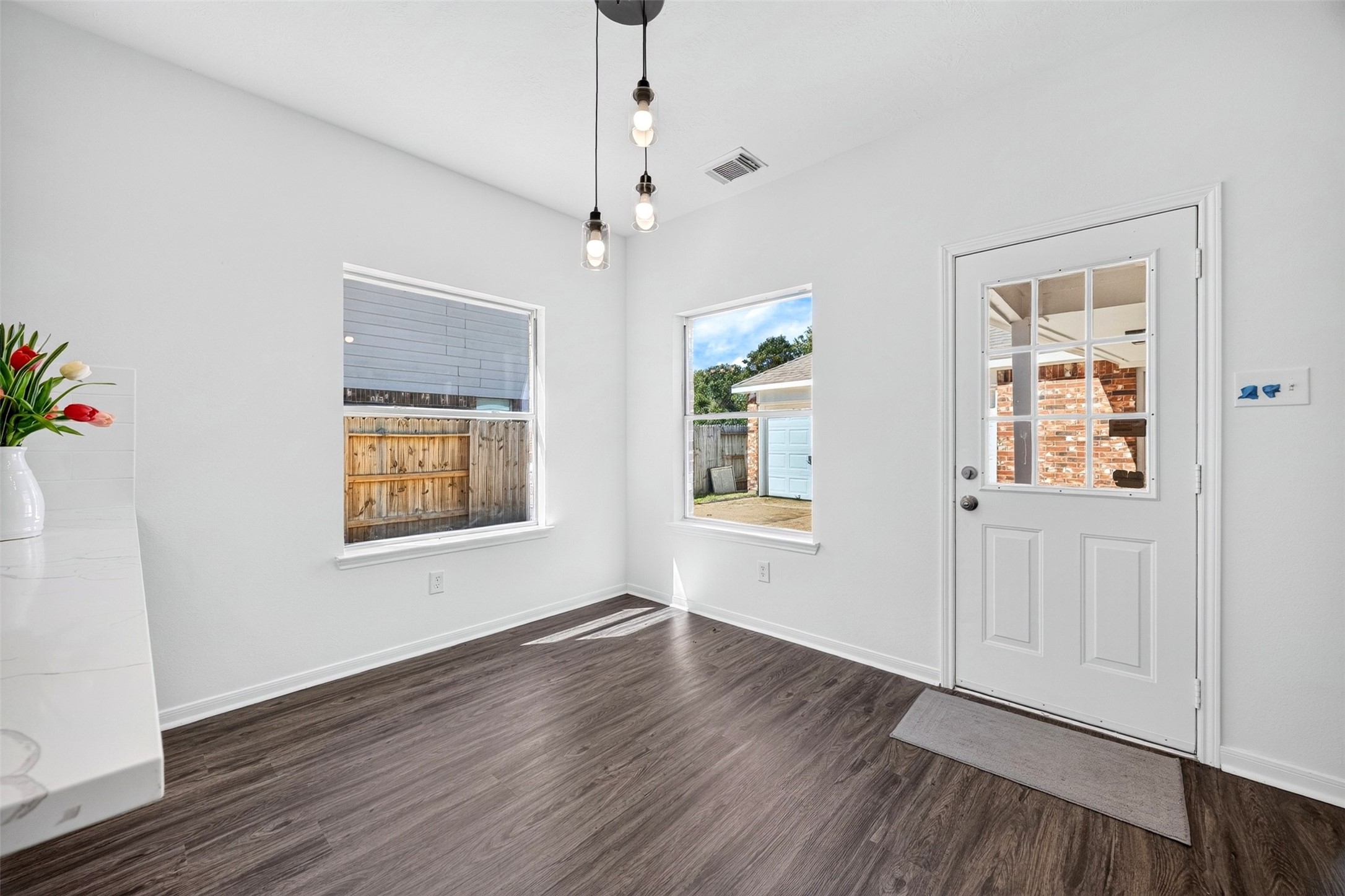 Bright and inviting breakfast area large windows, modern lighting, leading to a charming outdoor space.