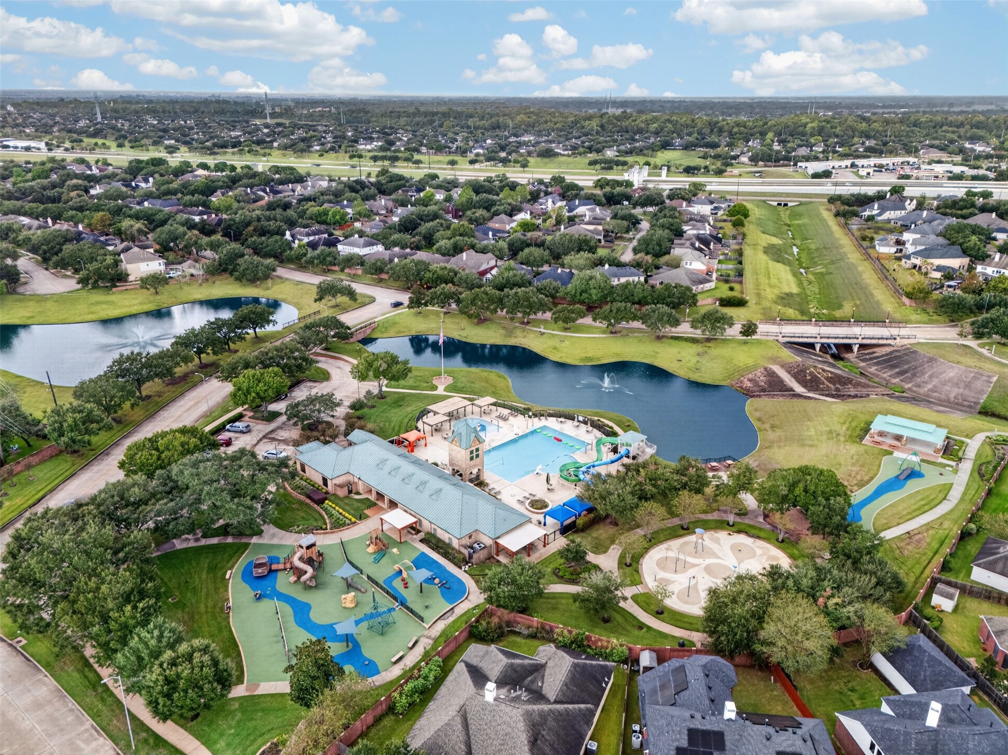 Discover a vibrant community featuring a spacious recreational area with a large swimming pool, playgrounds, and scenic water views, perfect for family fun and relaxation.