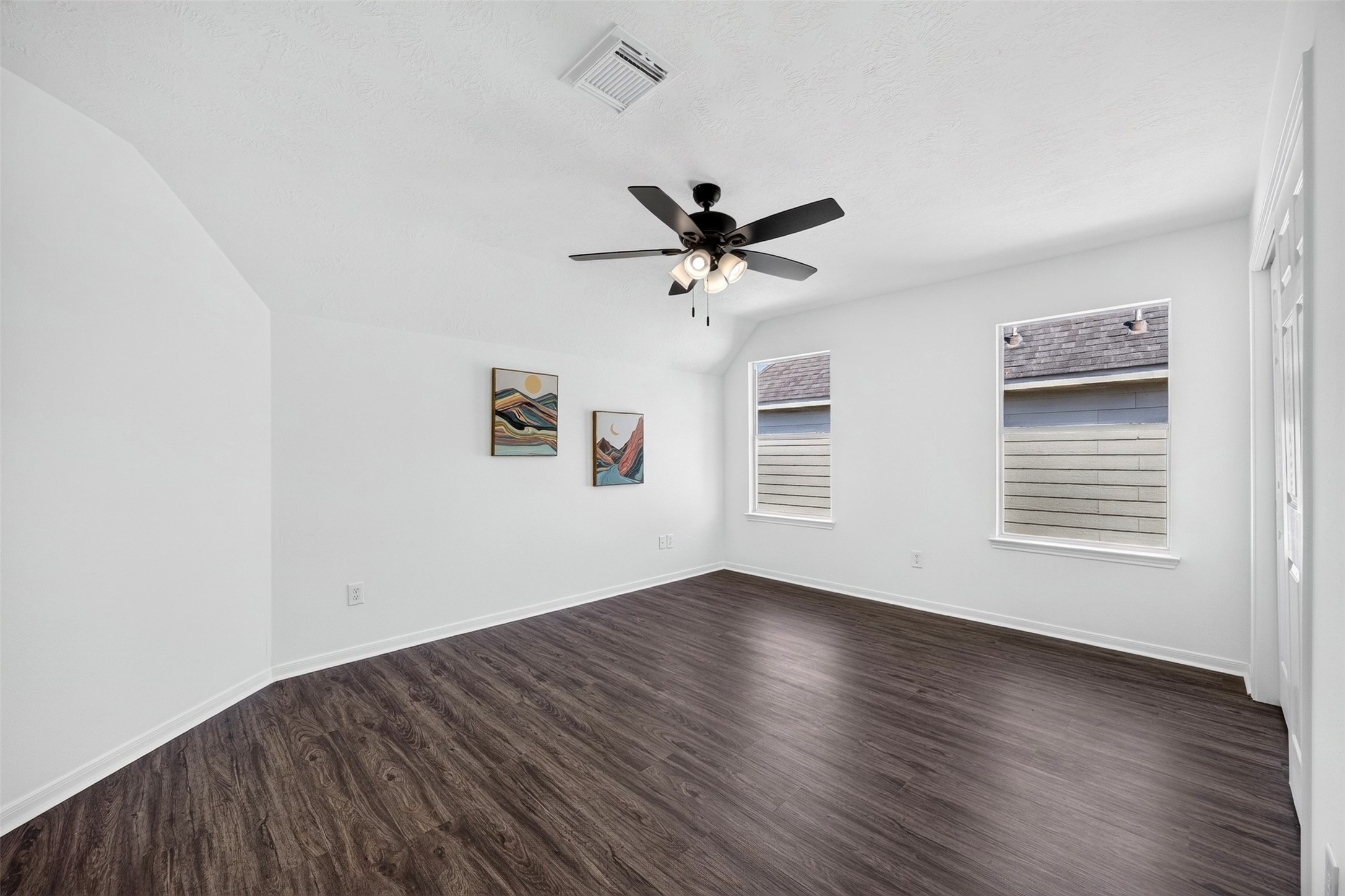 The bedroom has ample natural light from two windows