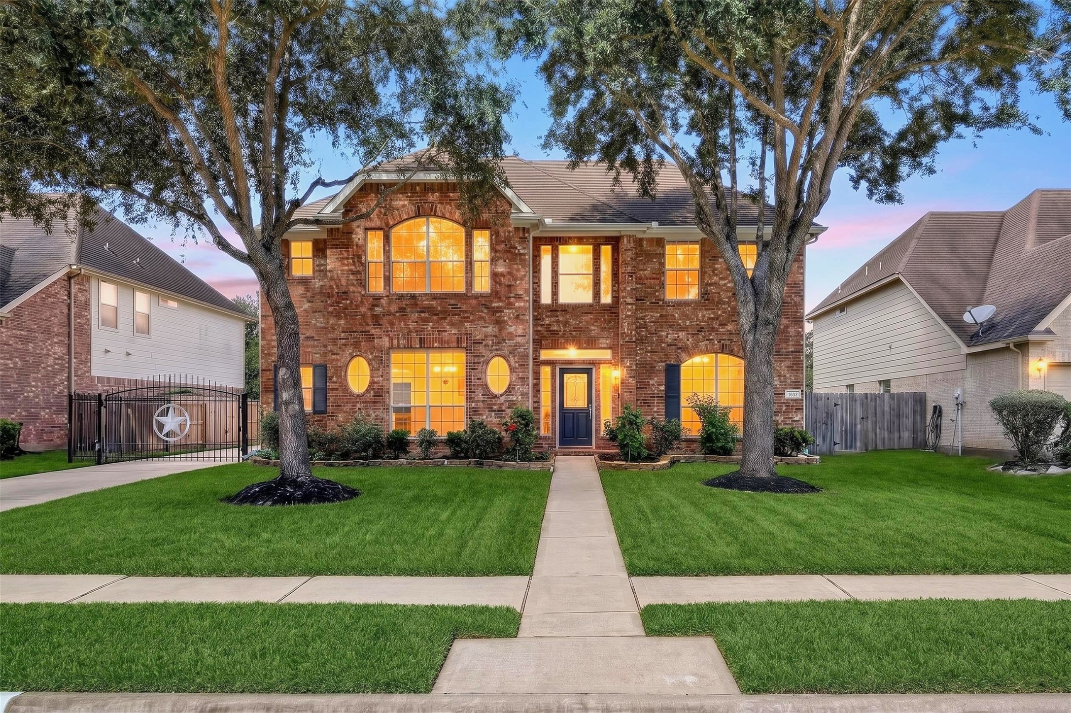 Charming two-story brick home with large, illuminated windows and a welcoming front entrance, nestled in a beautifully landscaped yard with mature trees. Charming two-story brick home with large, illuminated windows and a welcoming front entrance, nestled in a beautifully landscaped yard with mature trees.
