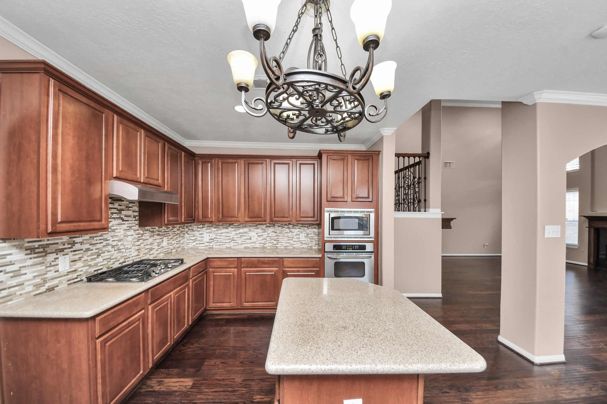 Elegant kitchen featuring rich wood cabinetry, modern stainless steel appliances, and a stylish tile backsplash. Elegant kitchen featuring rich wood cabinetry, modern stainless steel appliances, and a stylish tile backsplash.