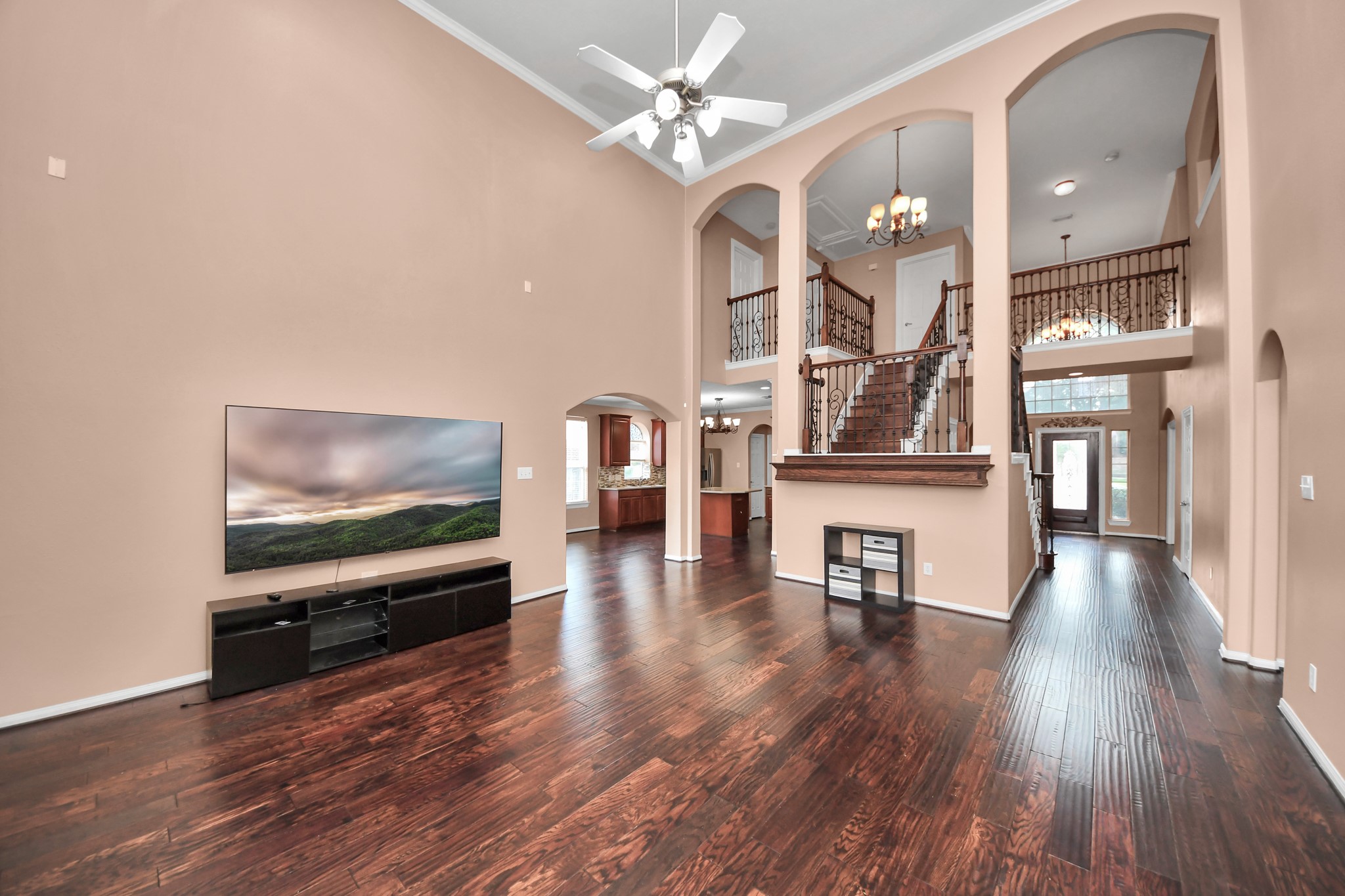 Stunning open-concept living space with high ceilings, elegant wood flooring, and a grand staircase, offering a blend of luxury and comfort perfect for entertaining. Stunning open-concept living space with high ceilings, elegant wood flooring, and a grand staircase, offering a blend of luxury and comfort perfect for entertaining.