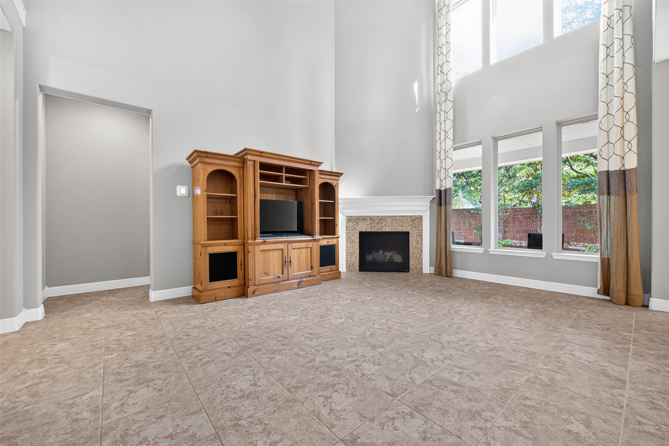 Living room featuring a cozy fireplace and large windows that provide abundant natural light