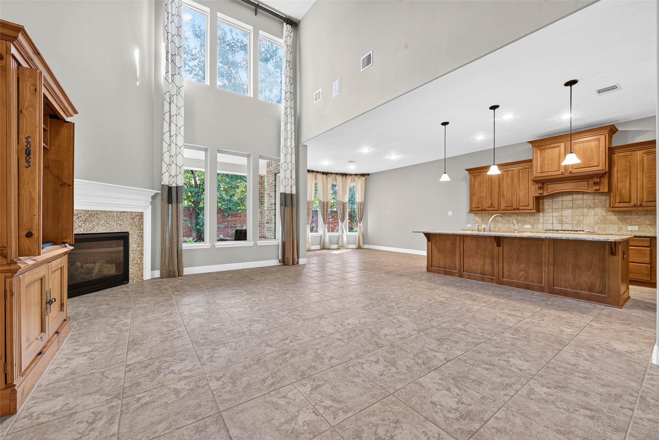 This stunning home features soaring high ceilings and oversized windows that bathe the living area in natural light, creating a seamless, open-concept flow into the dining and kitchen spaces. This stunning home features soaring high ceilings and oversized windows that bathe the living area in natural light, creating a seamless, open-concept flow into the dining and kitchen spaces.