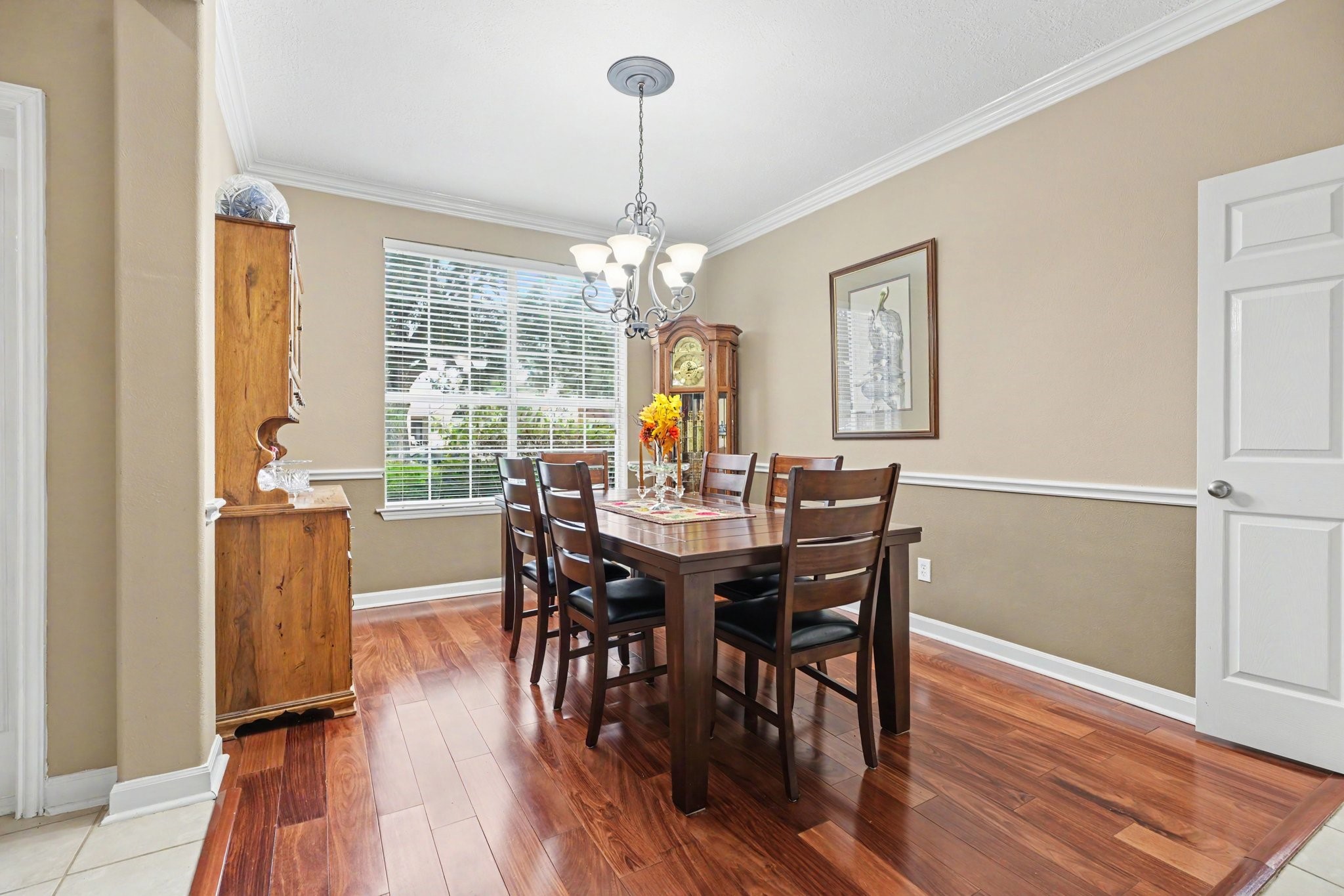 Dining room with beautiful cherry wood floors, crown molding and chair railing
