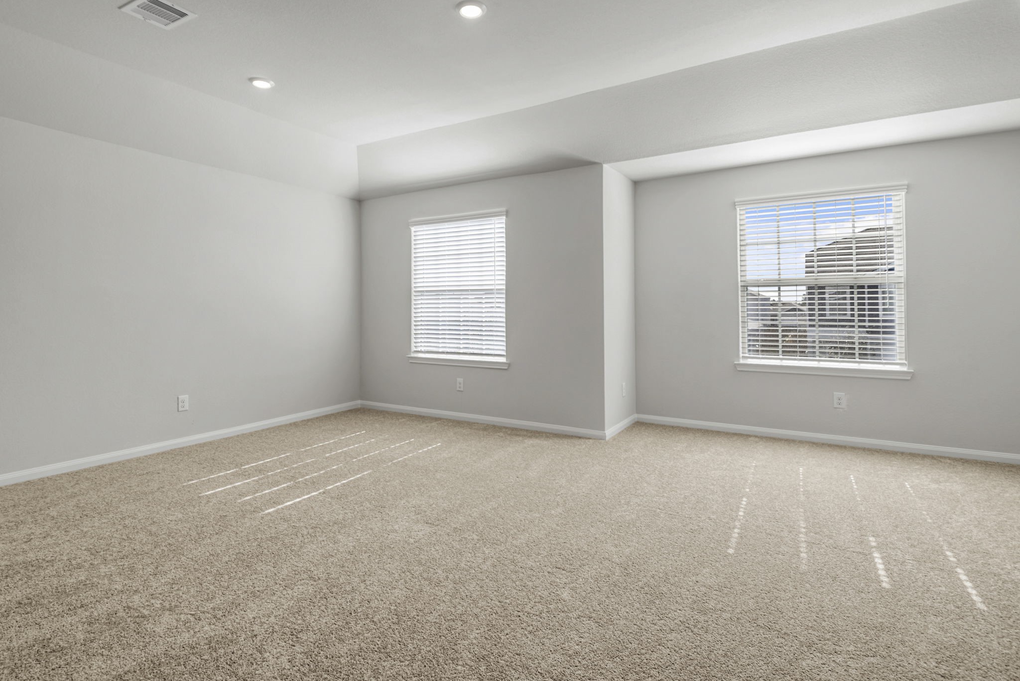 The large, primary bedroom with beautiful windows.