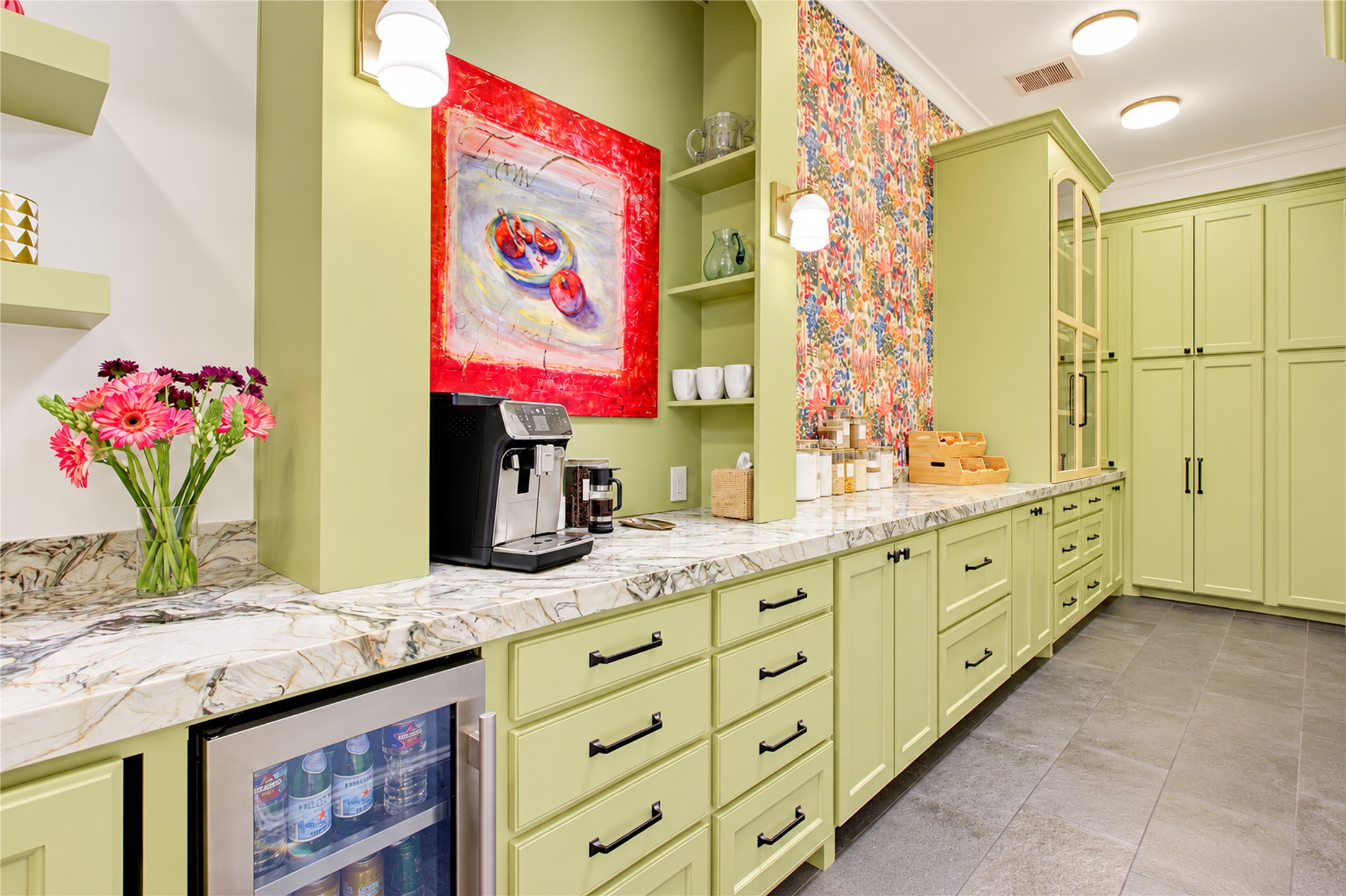 Soft sage-green cabinetry and distinctive Green Fusion quartzite countertops bring refined character to this dedicated prep kitchen.