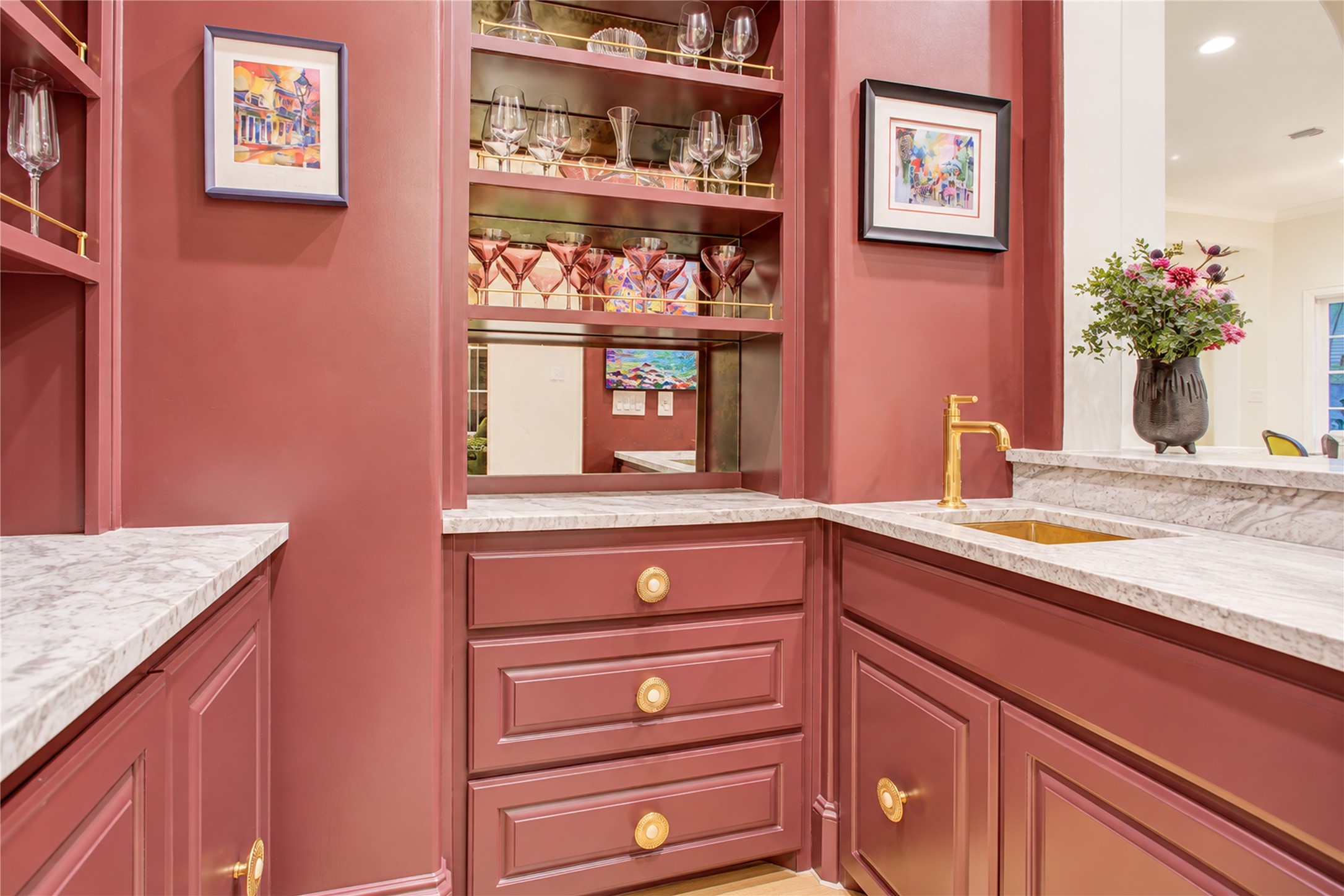 An arched alcove frames this refined wet bar, where deep merlot soft-close cabinetry adds depth and distinction.