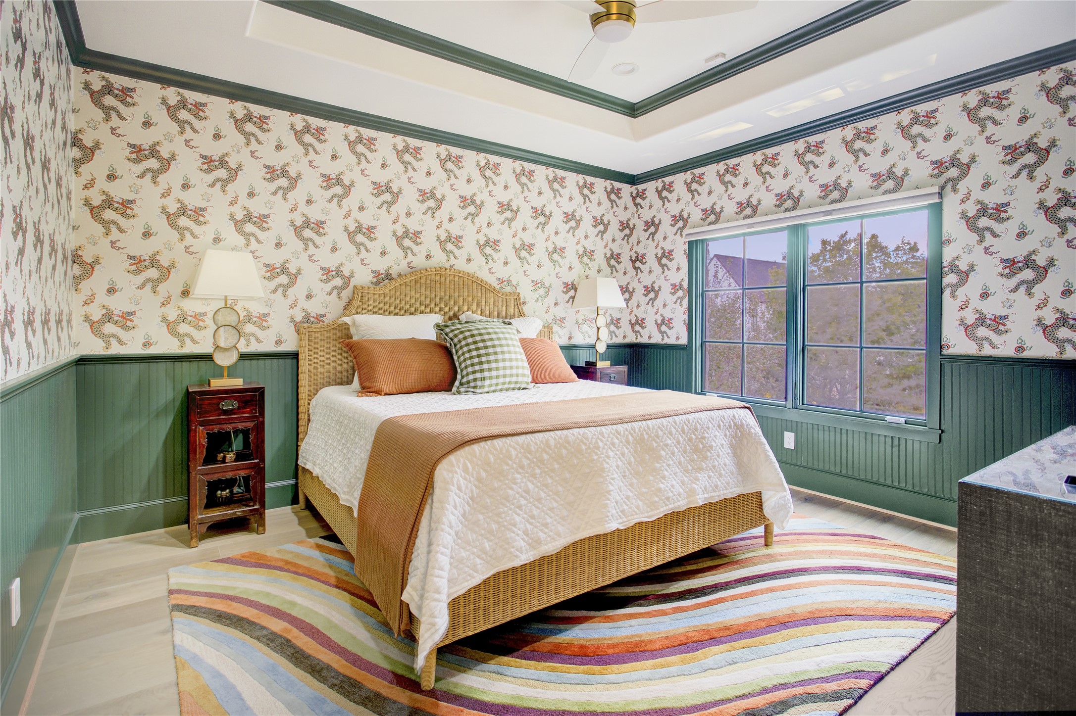 Designer dragon wallpaper and rich green millwork bring bold character to this secondary bedroom, finished with a 10-foot tray ceiling.
