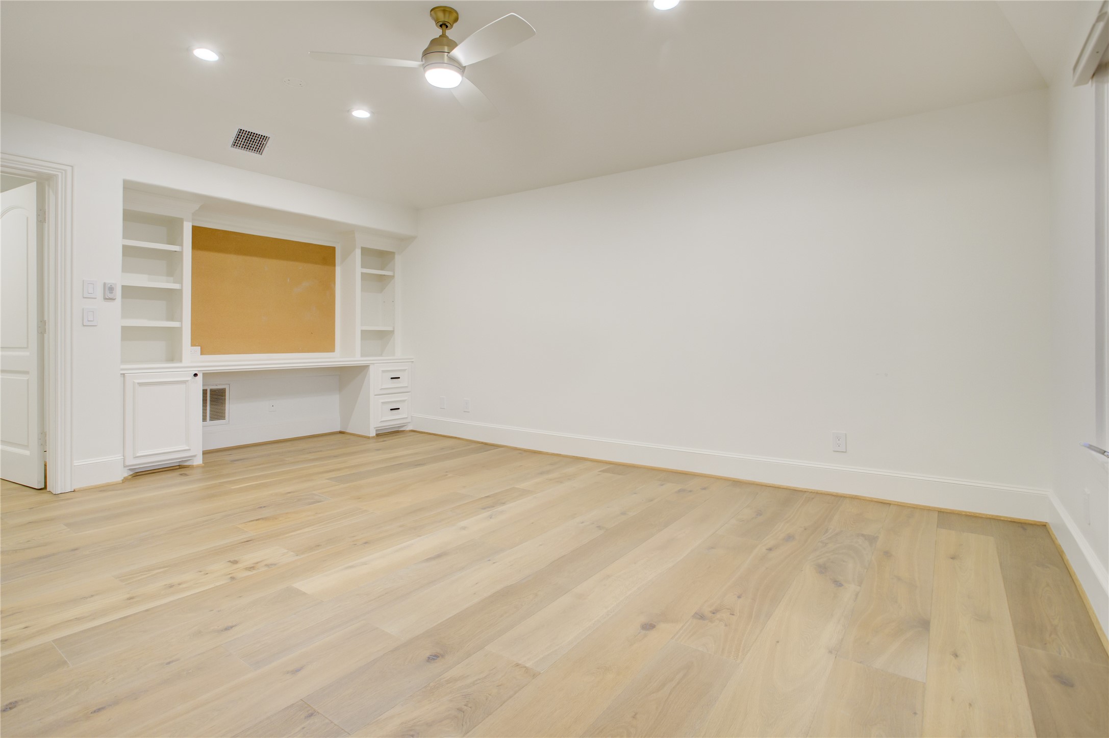 A versatile fifth bedroom on its own level, complete with vaulted ceilings and a built-in desk for work or study.