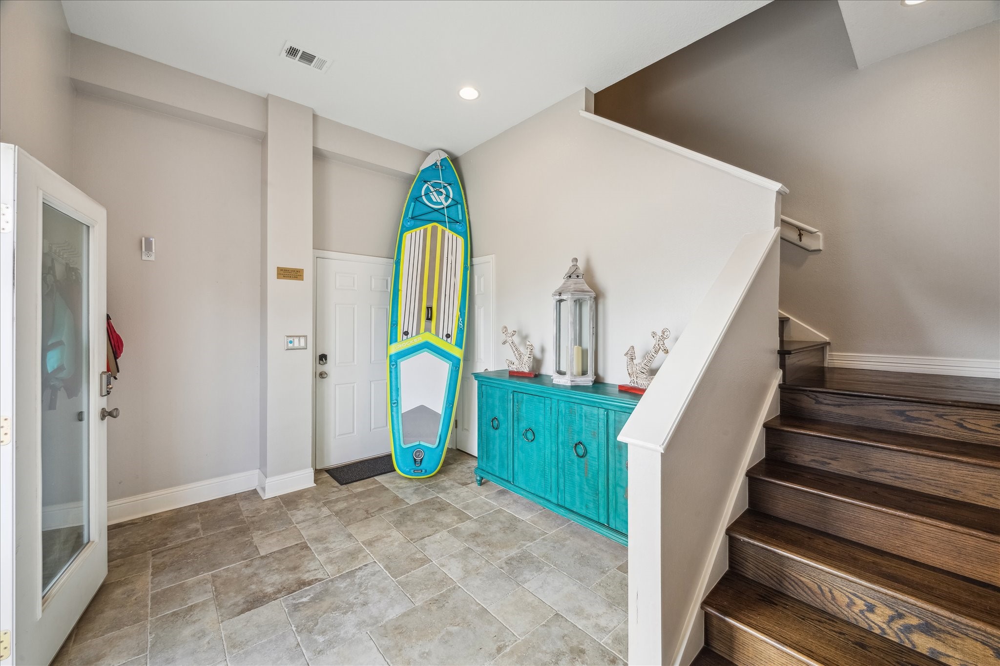 Bright , welcoming entryway featuring tiled flooring and a vibrant turquoise console.  Ideal for welcoming guests with style.