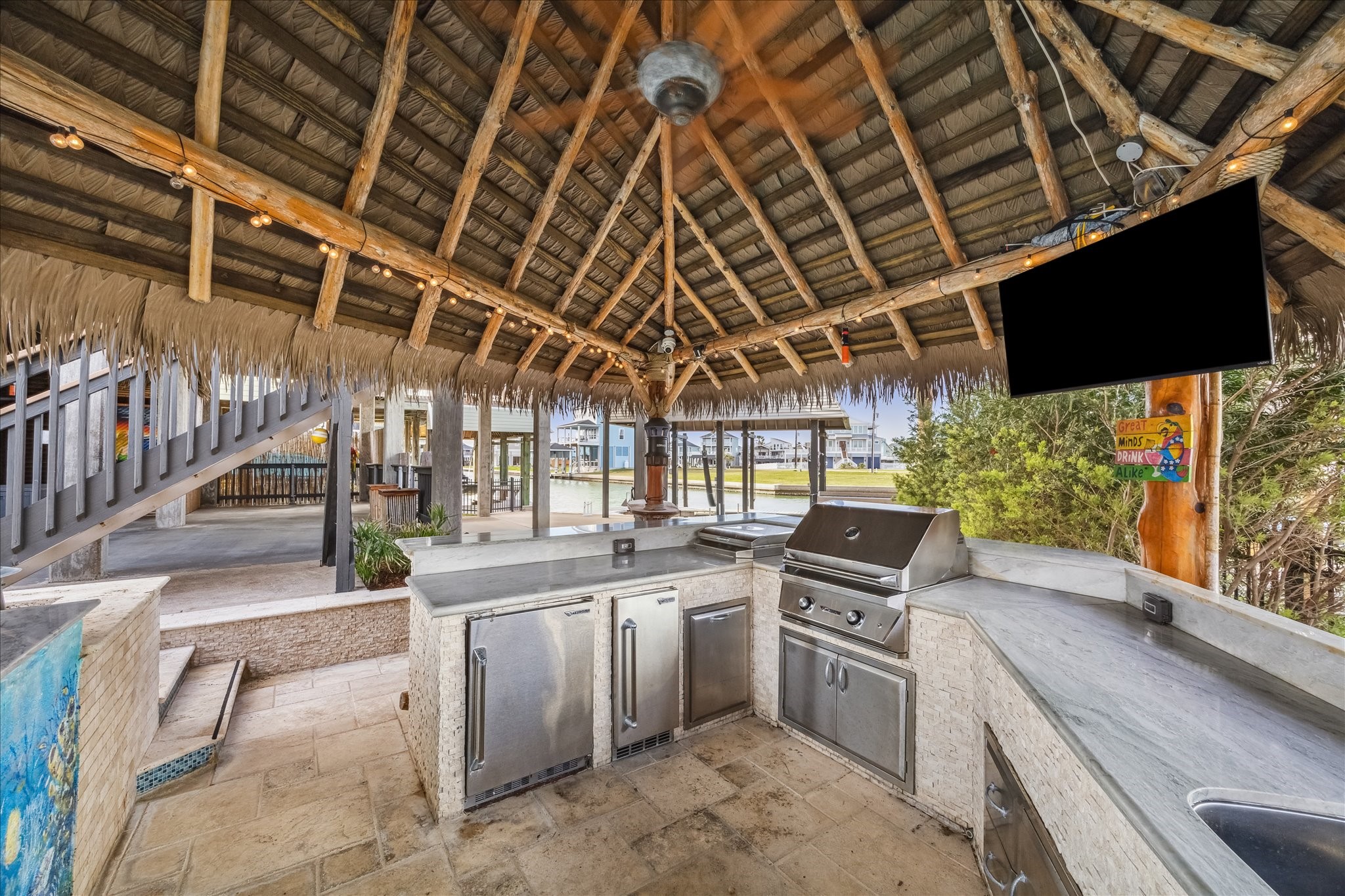 The outdoor kitchen features stainless steel appliances, a grill, and ample counter space. It offers a relaxed, tropical ambiance perfect for entertaining. The outdoor kitchen features stainless steel appliances, a grill, and ample counter space. It offers a relaxed, tropical ambiance perfect for entertaining.