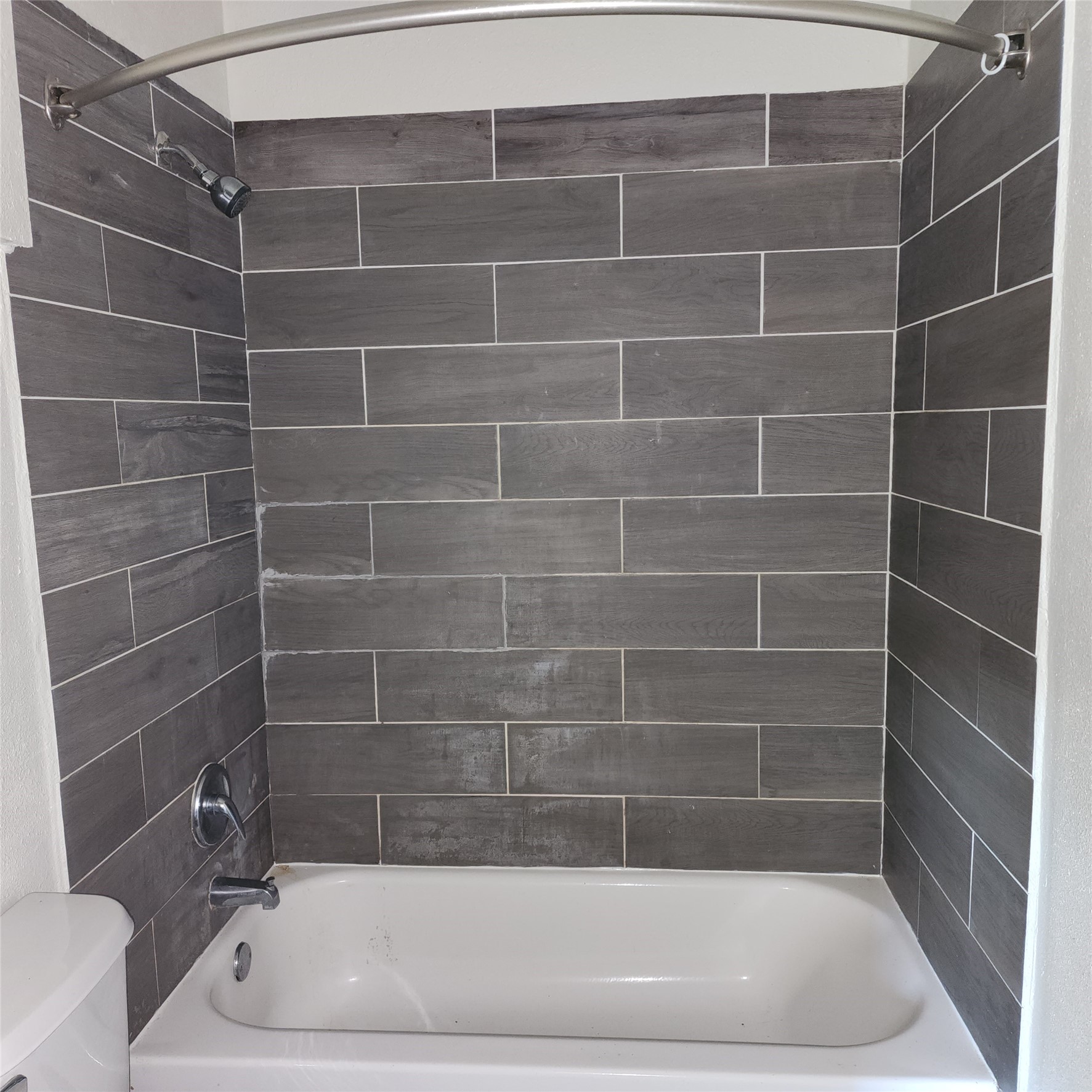 Shower with tiled tub surround.