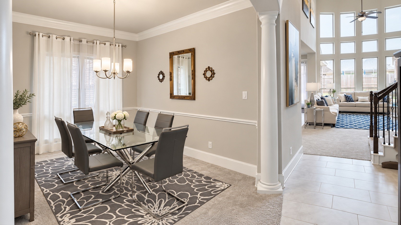 Living Room + Staircase  Open living area highlighted by the fireplace, curved staircase, high ceilings, and abundant natural light. [Virtually Staged & Rendered]