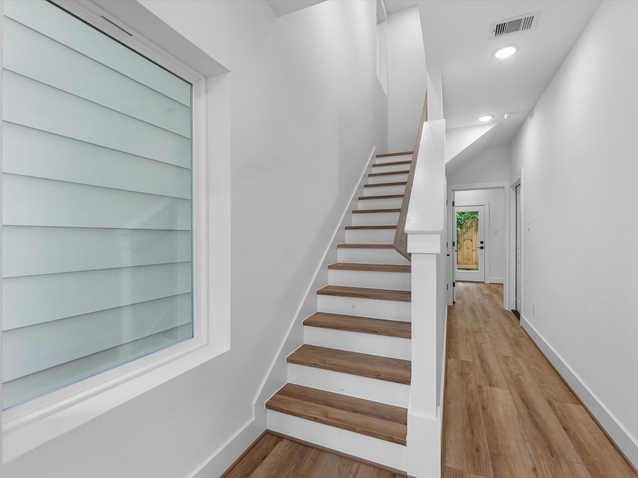 Welcoming entryway with a spacious closet and additional storage tucked neatly beneath the stairs. The first floor also features a bedroom with a full bath and direct access to the backyard, offering added convenience and privacy.