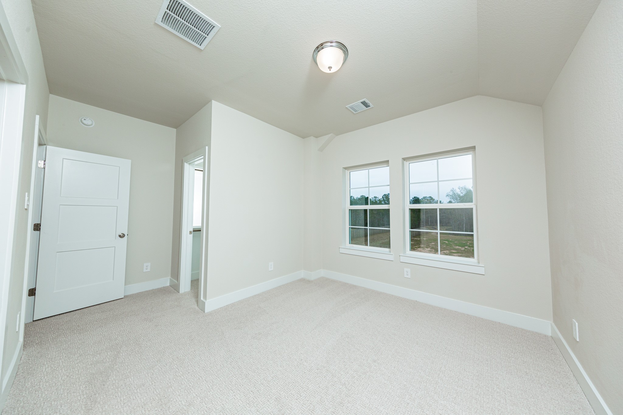 This inviting secondary bedroom boast of the two large windows, plush carpeting, a neutral color palette, and easy access to the secondary bathroom.