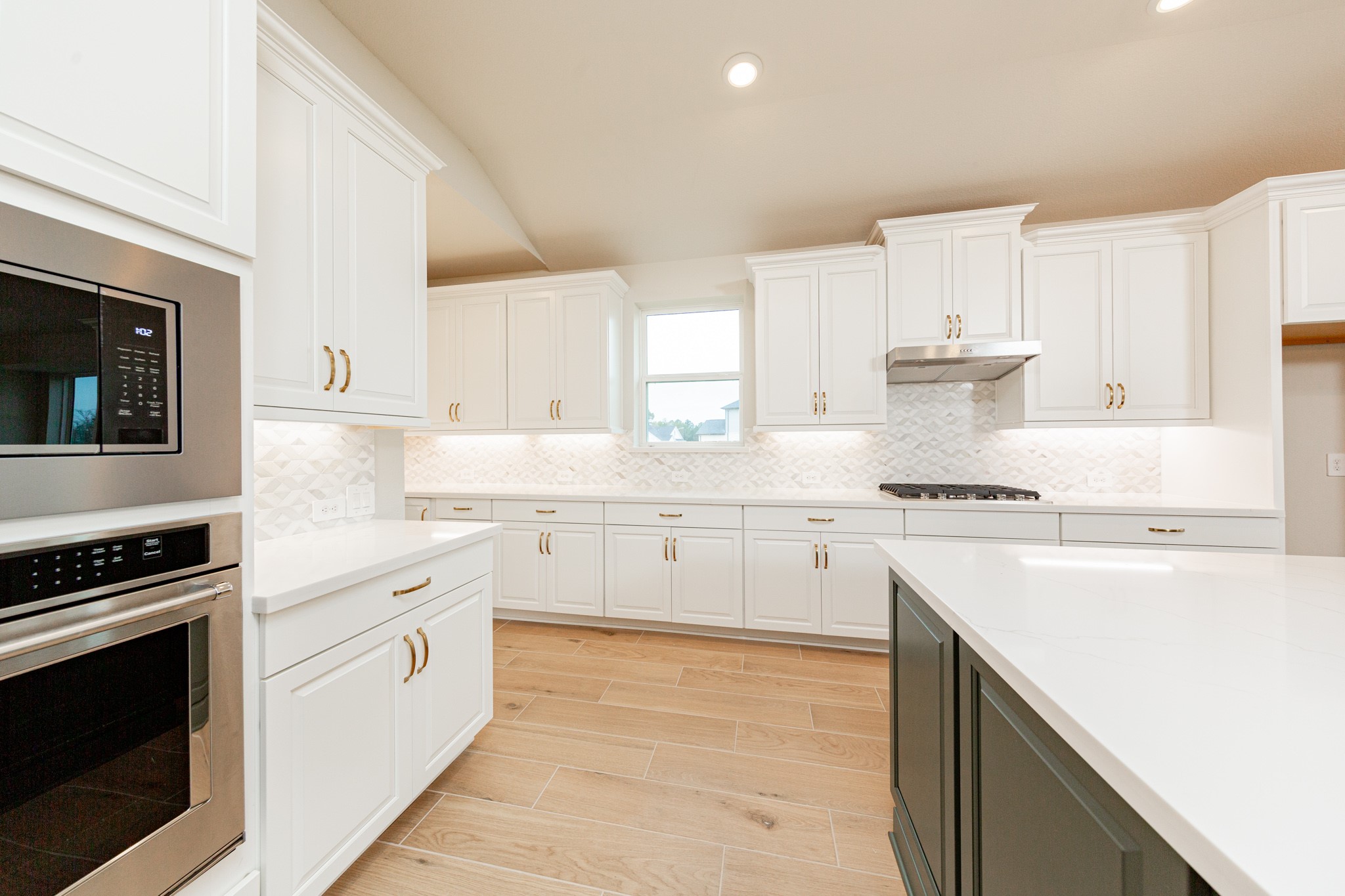 This gourmet, open-concept kitchen is truly the heart of the home, meticulously designed with both aesthetics and functionality in mind. White Shaker-style cabinetry that extends to the ceiling, offering maximum storage space. Quartz countertops, modern backsplash and gold-tones hardware giving it all a touch of luxury.