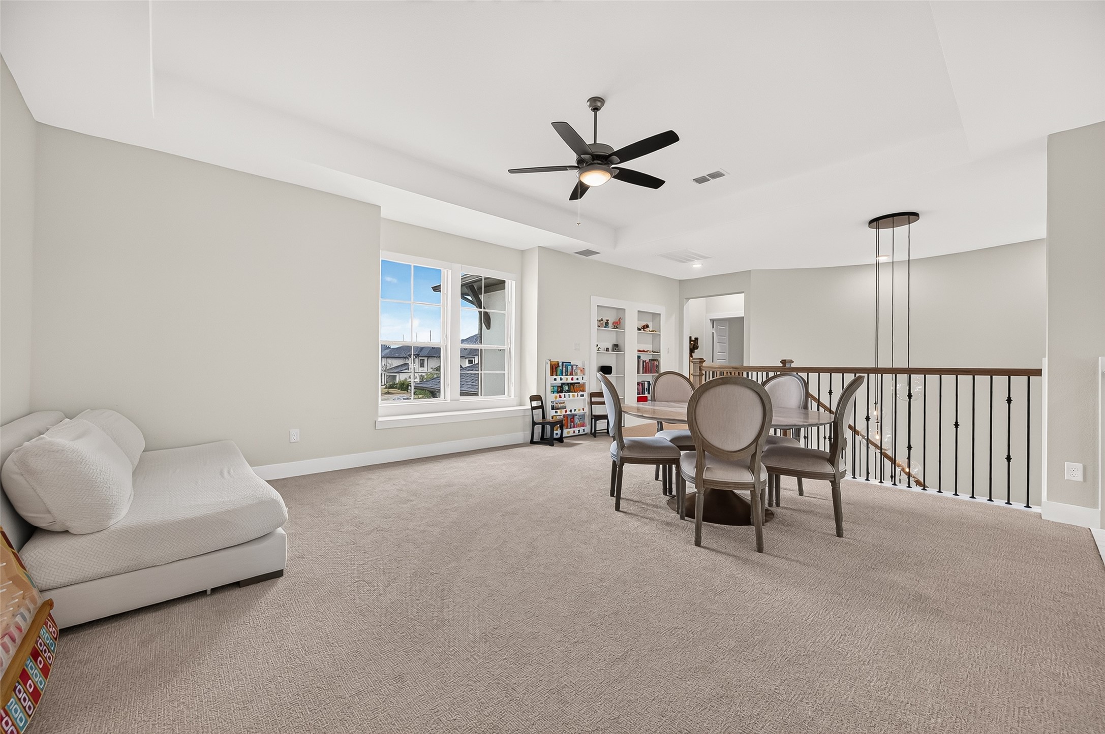 Upstairs, the spacious game room features built-in bookshelves and a hidden/secret opening leading to additional storage.