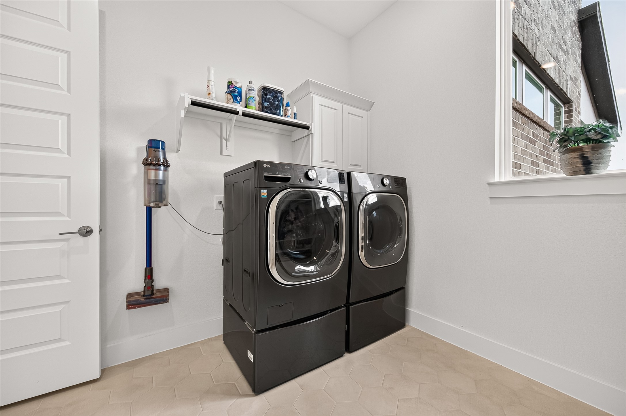 A large laundry room offers built-in cabinetry, hanging racks, and a convenient mud-drop area.