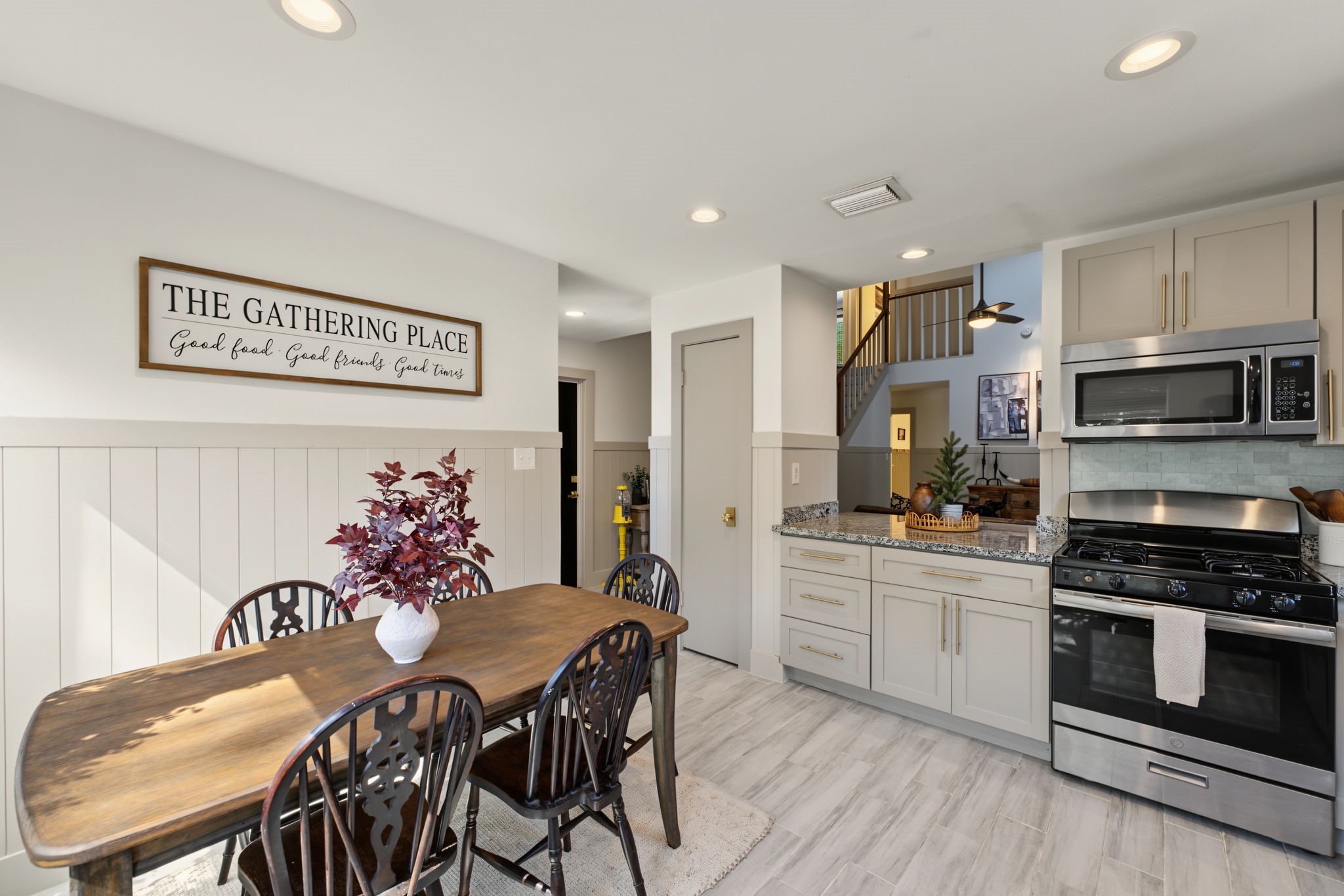 Sunny breakfast nook is lined with windows and shiplap wainscoting, the perfect spot for your morning coffee!