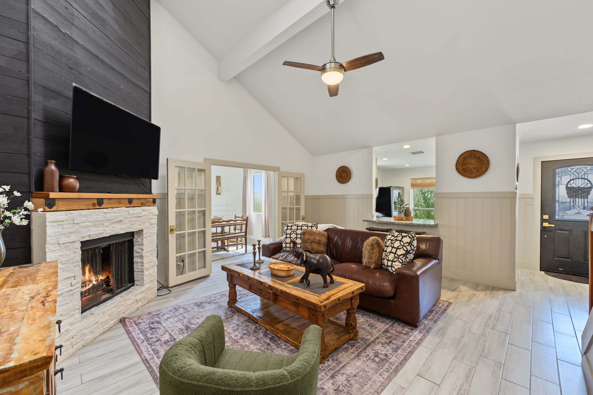 Cozy up by the fireplace! French doors lead to the flex room, and shiplap wainscoting adds charm throughout.