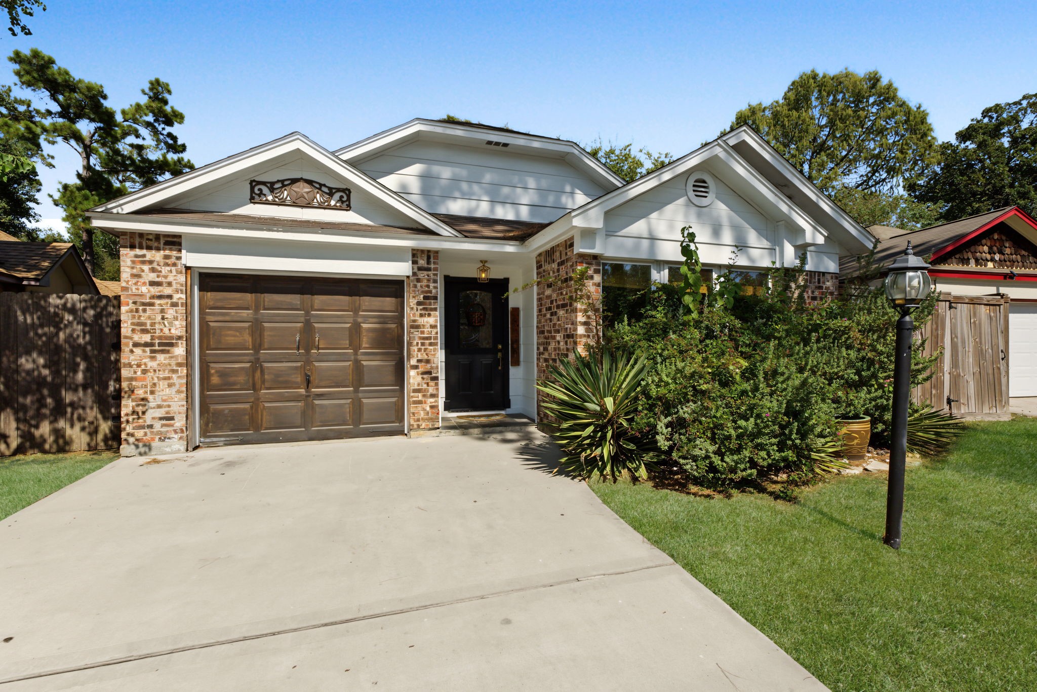 Inviting curb appeal with a decorative Texas star gable accent and wood-tone garage door.