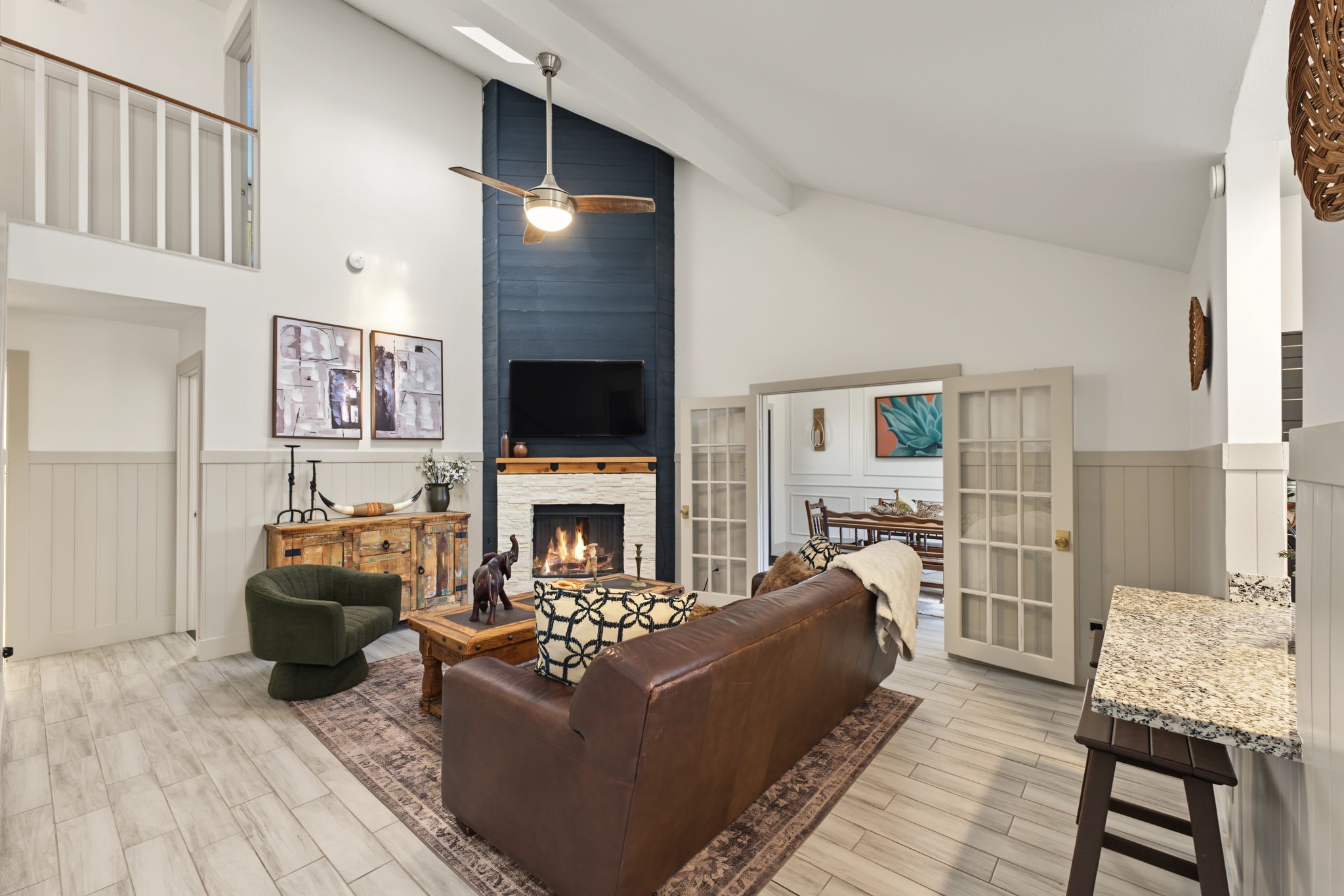 Living room sits beneath the upstairs landing and flows to the granite breakfast bar.