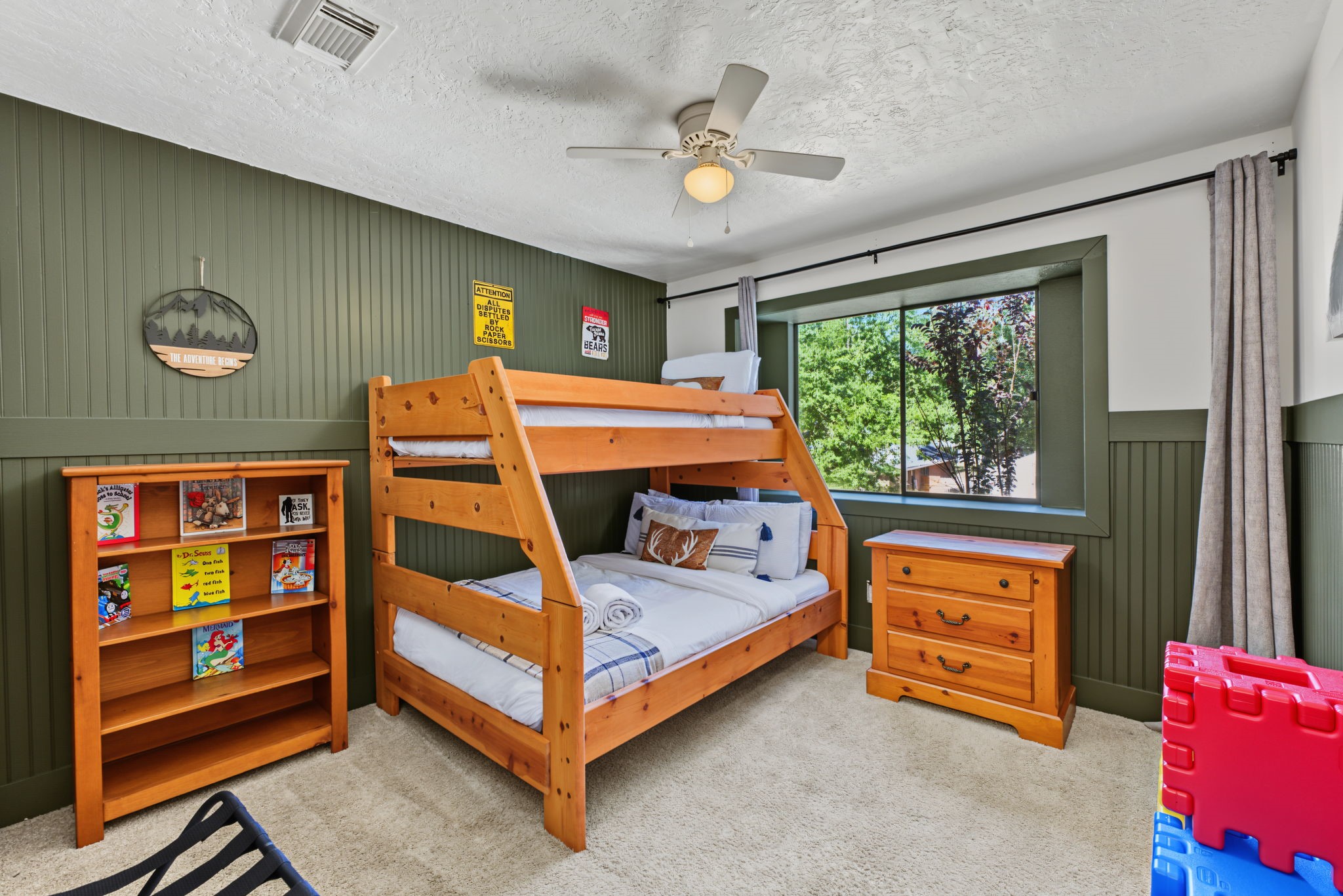 Secondary bedroom #3 boasts a deep green beadboard accent wall, perfect for a kids' room or playroom!