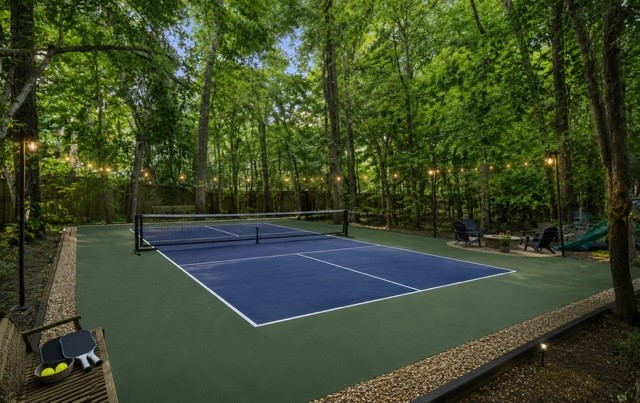 Experience ultimate outdoor leisure with this virtually staged pickleball court nestled amid lush greenery, perfect for both relaxation and recreation.