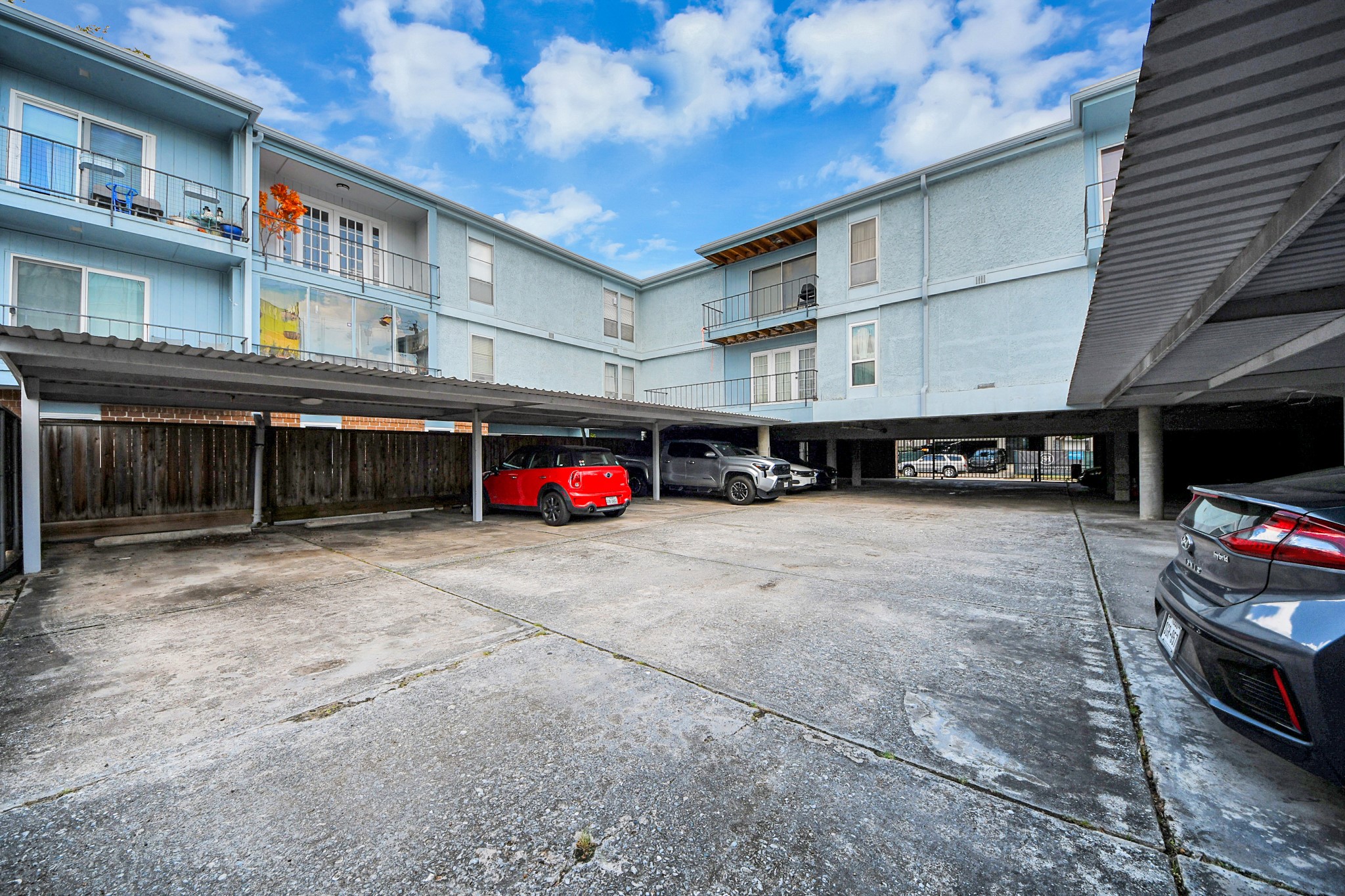 Spacious community parking area with convenient covered parking and easy access to the building.