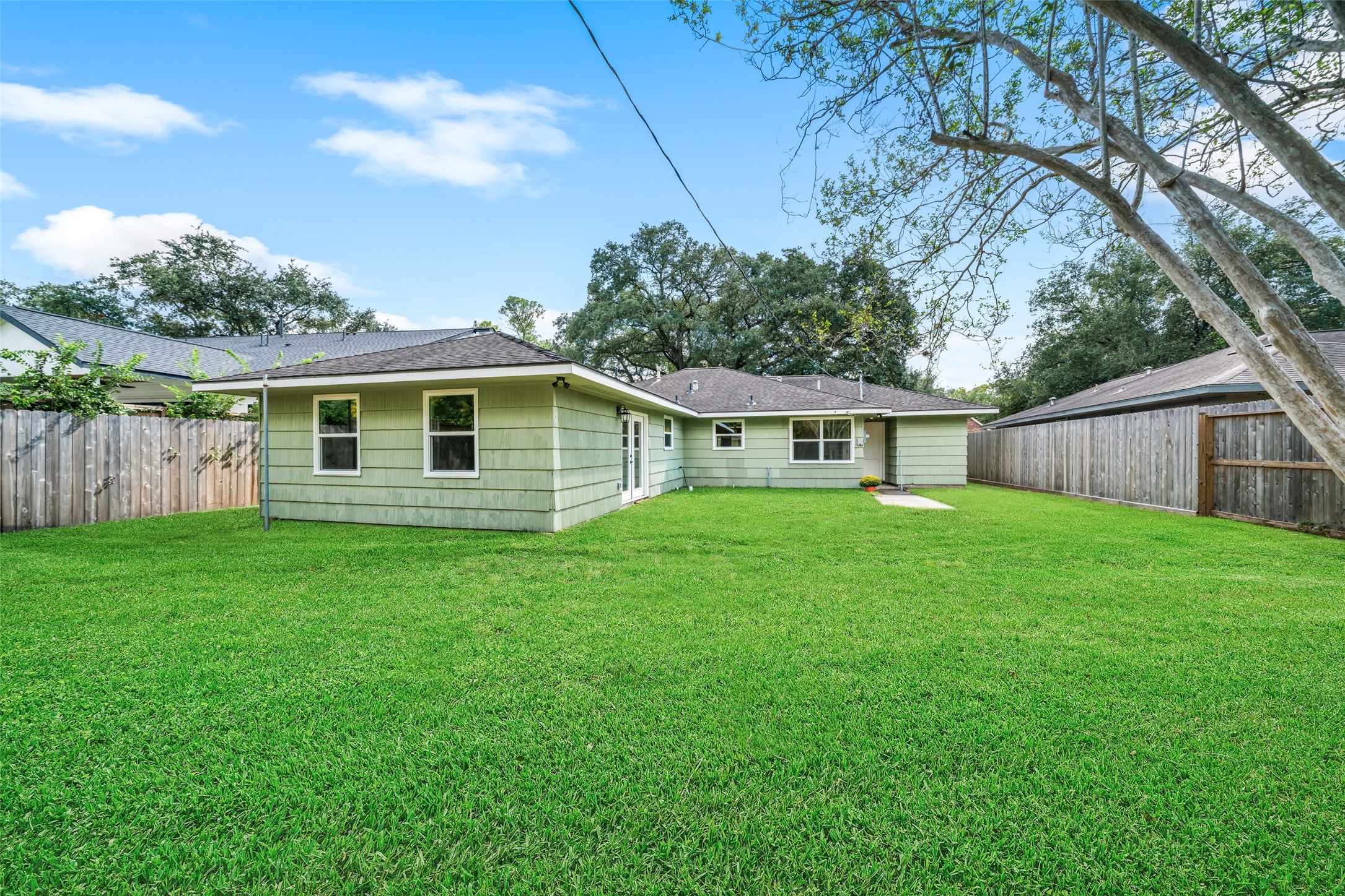 Spacious backyard with lush green lawn and privacy fencing, ideal for outdoor activities and relaxation.